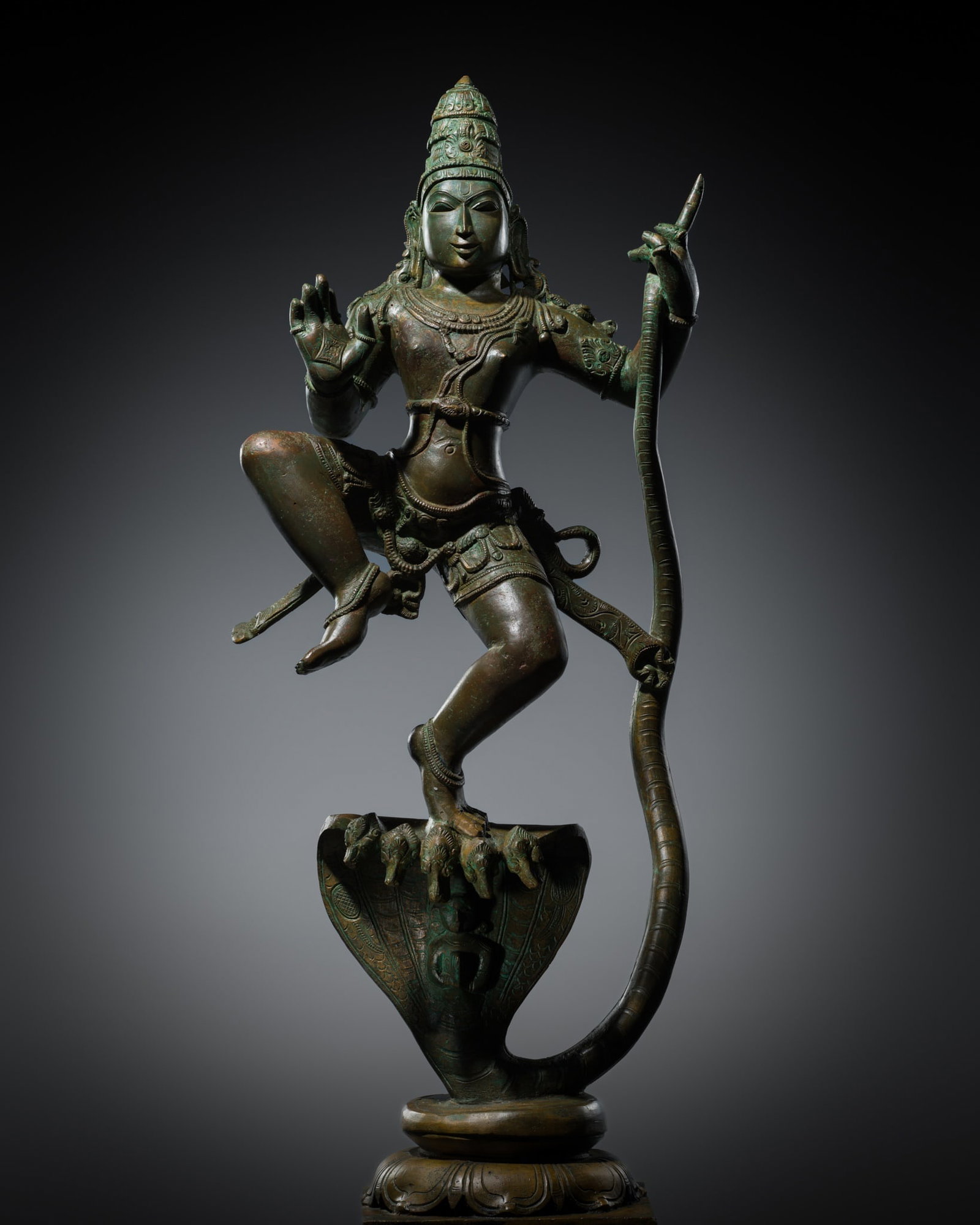 A LARGE COPPER ALLOY FIGURE OF KRISHNA OVERCOMING THE SERPENT KING KALIYA, 18TH-19TH CENTURY: A LARGE COPPER ALLOY FIGURE OF KRISHNA OVERCOMING THE SERPENT KING KALIYA, 18TH-19TH CENTURY South India. Finely cast with Krishna dancing victoriously on the back of the multi-headed serpent, raised 
