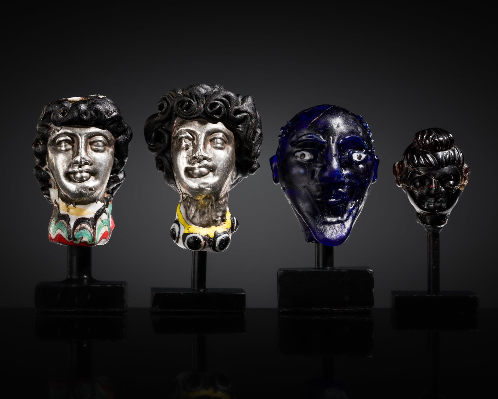 A GROUP OF FOUR ANCIENT GLASS AND SILVER HEADS (1 of 20)