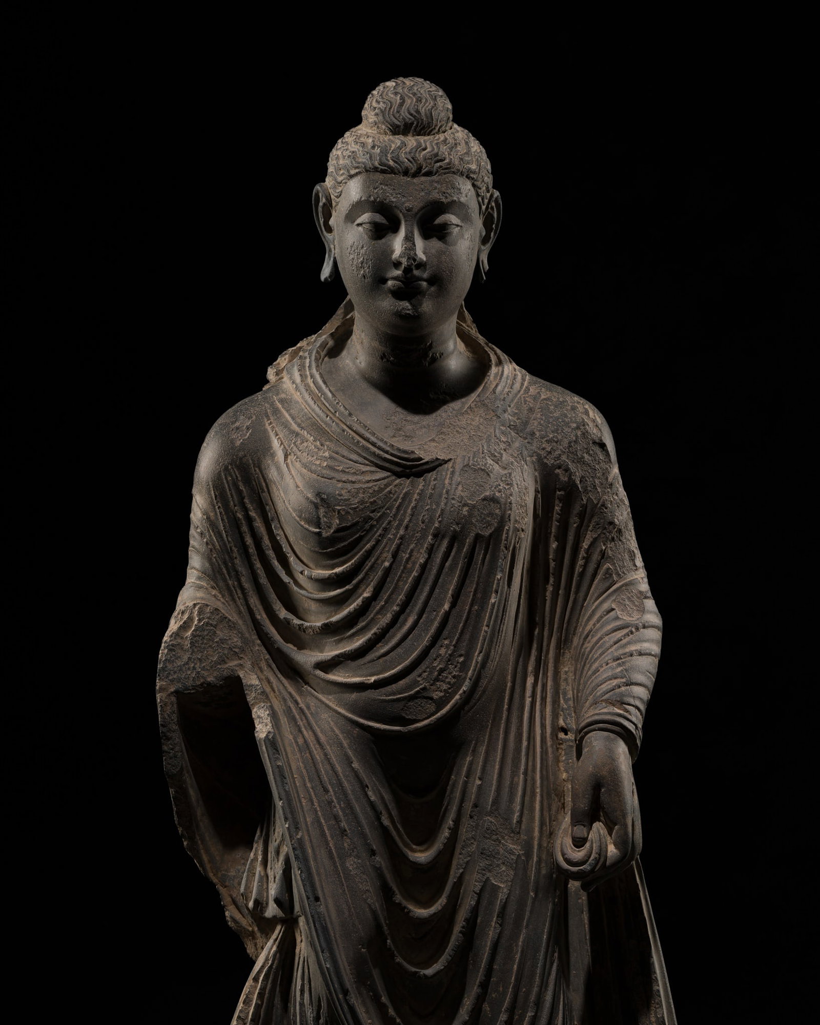 A LARGE AND FINE GRAY SCHIST FIGURE OF BUDDHA SHAKYAMUNI, ANCIENT REGION OF GANDHARA, 2ND-3RD: A LARGE AND FINE GRAY SCHIST FIGURE OF BUDDHA SHAKYAMUNI, ANCIENT REGION OF GANDHARA, 2ND-3RD CENTURY Kushan period. Finely carved, standing in samabhanga on a rectangular plinth carved in relief to