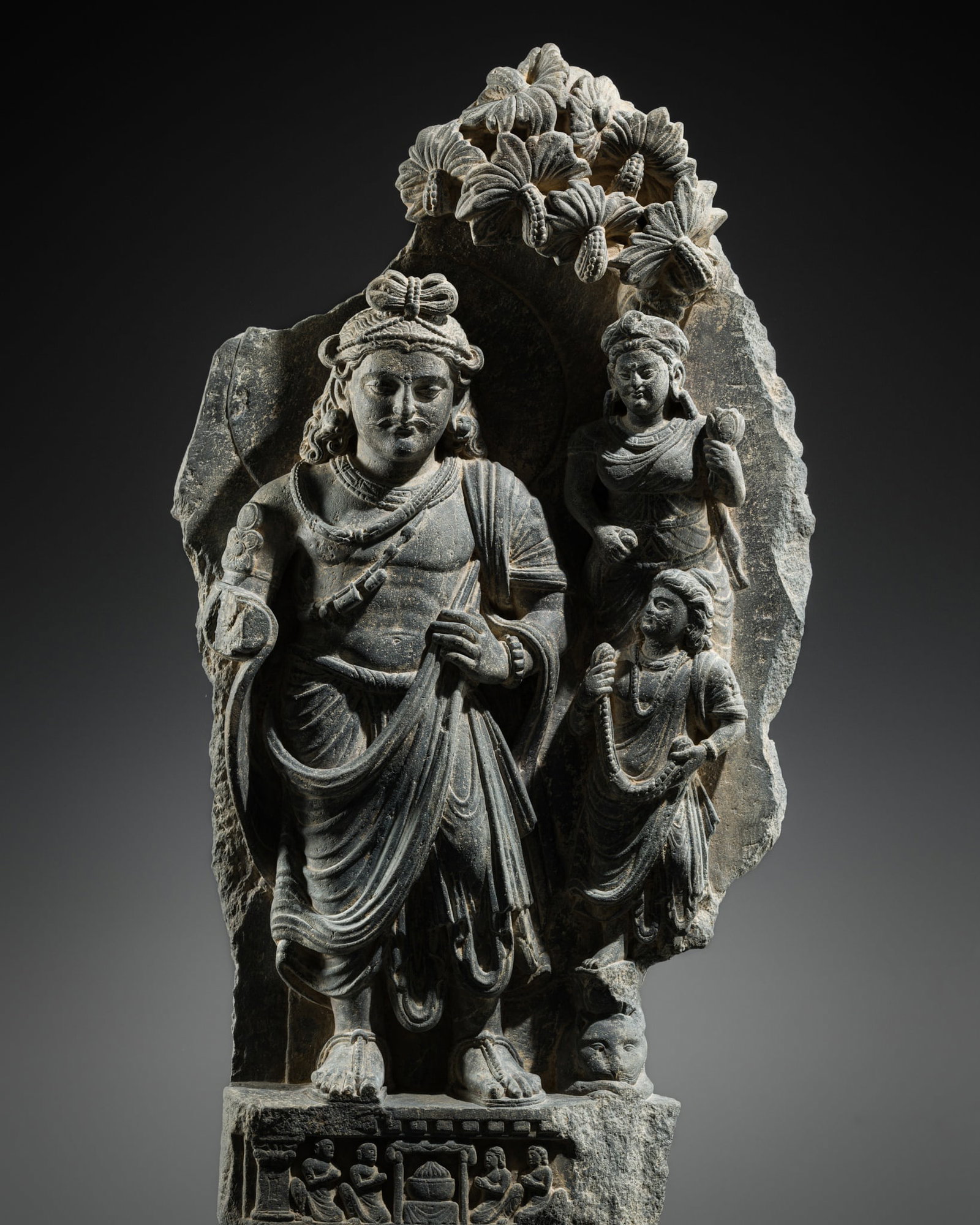A GRAY SCHIST RELIEF DEPICTING SIDDHARTHA WITH NOBLE PATRONS, ANCIENT REGION OF GANDHARA, 2ND-4TH: A GRAY SCHIST RELIEF DEPICTING SIDDHARTHA WITH NOBLE PATRONS, ANCIENT REGION OF GANDHARA, 2ND-4TH CENTURY Finely carved to depict Siddhartha, dressed in the garb of an Indian prince, with an