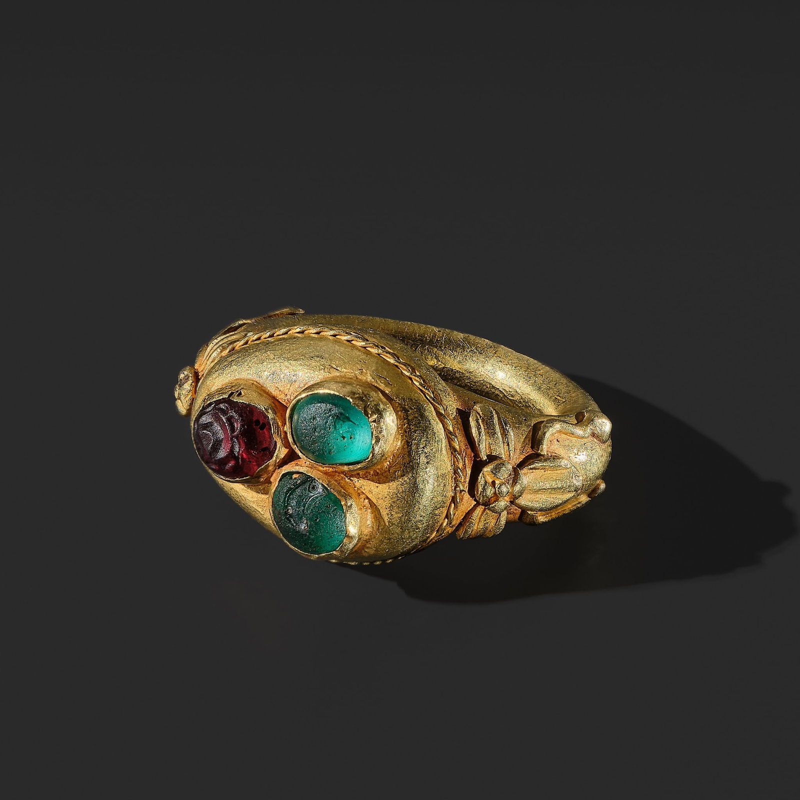 A GOLD AND GLASS PASTE 'THREE BUDDHIST JEWELS' (TRIRATNA) RING, JAVA, CIRCA 12TH CENTURY (1 of 16)