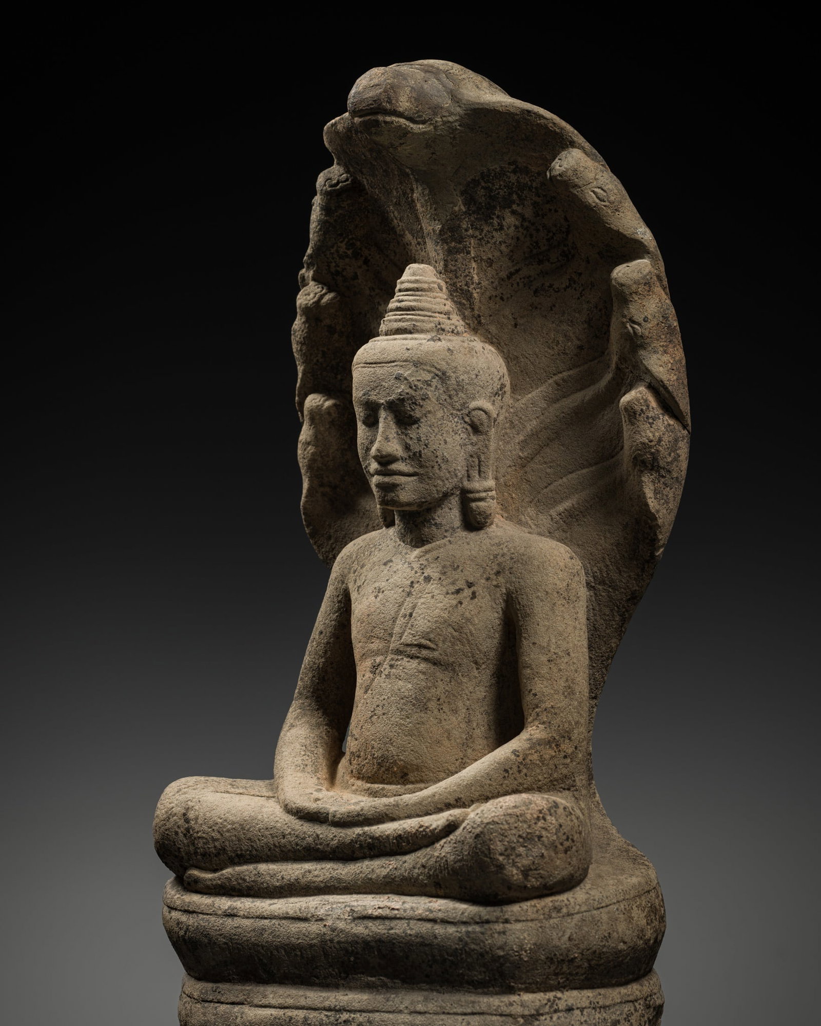 A SANDSTONE FIGURE OF BUDDHA MUCHALINDA, ANGKOR PERIOD, BAYON STYLE, LATE 12TH-EARLY 13TH CENTURY (1 of 17)