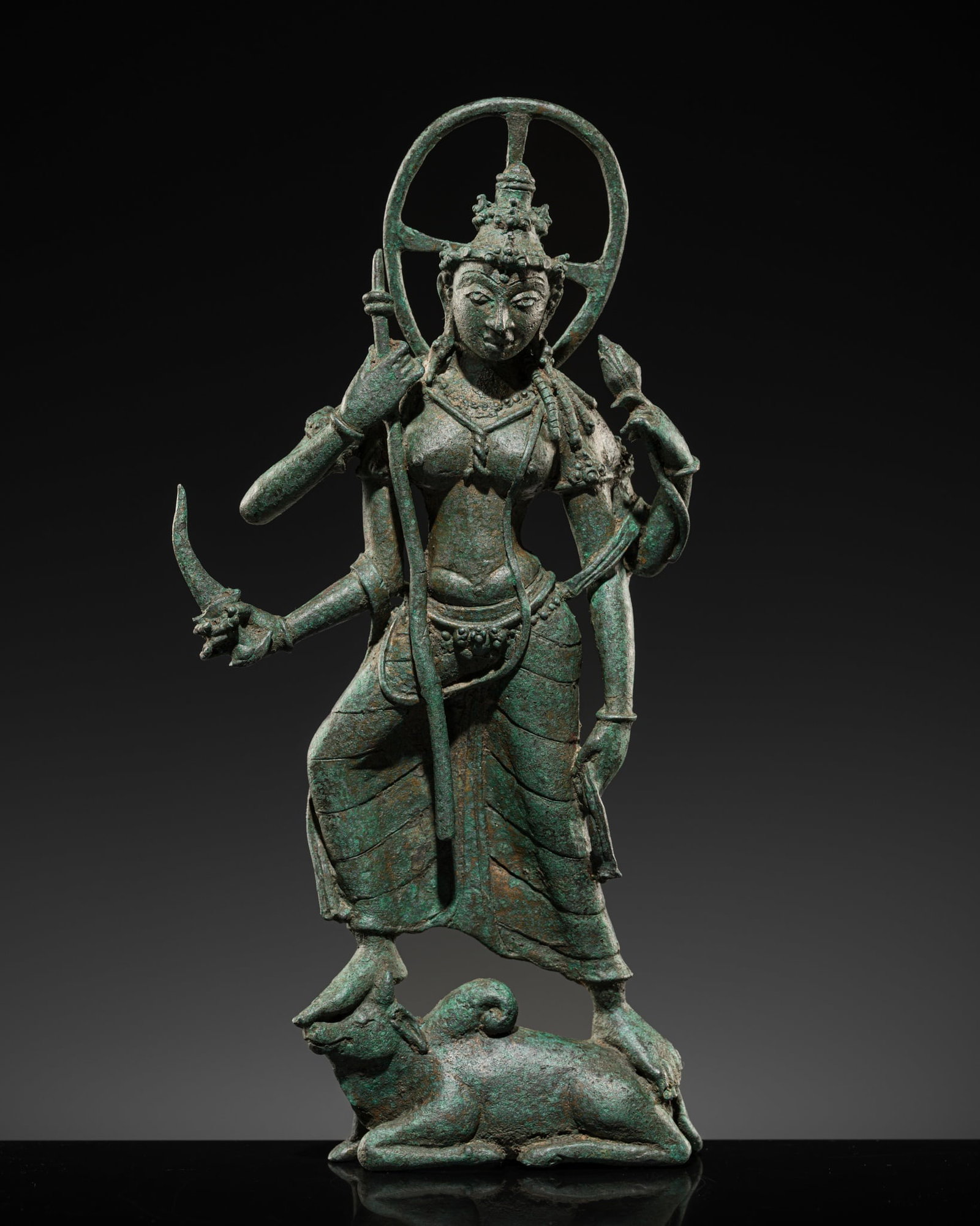 A RARE BRONZE FIGURE OF DURGA KILLING THE BUFFALO DEMON, CENTRAL JAVA, 9TH-10TH CENTURY: A RARE BRONZE FIGURE OF DURGA KILLING THE BUFFALO DEMON, CENTRAL JAVA, 9TH-10TH CENTURY Indonesia. Striding in aldhiasana atop the buffalo demon, with four arms radiating around her body, she holds a 