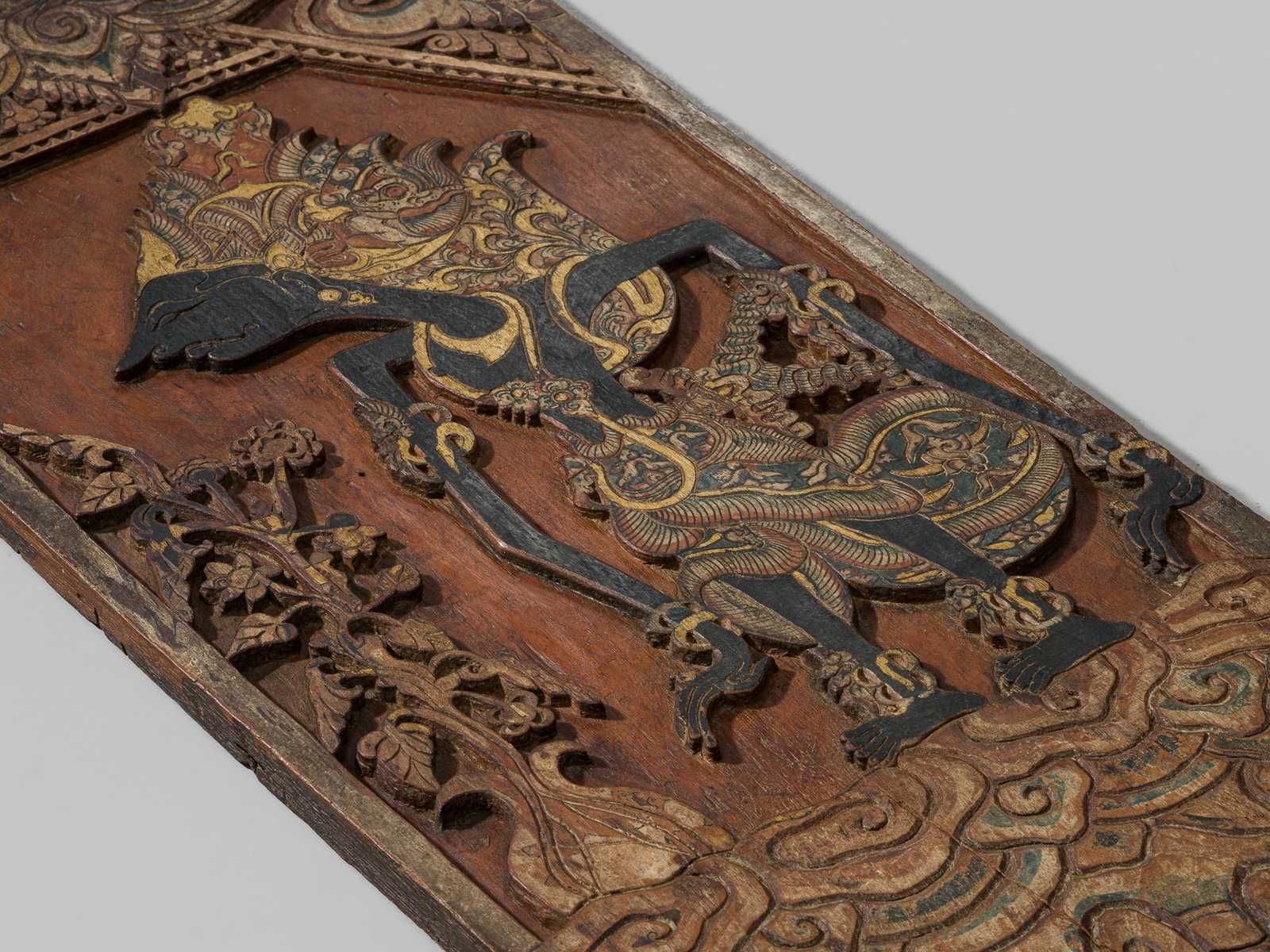 A RARE POLYCHROME WOOD 'WAYANG' BLAWONG (KRIS DISPLAY BOARD) DEPICTING ARJUNA, JAVA (1 of 9)