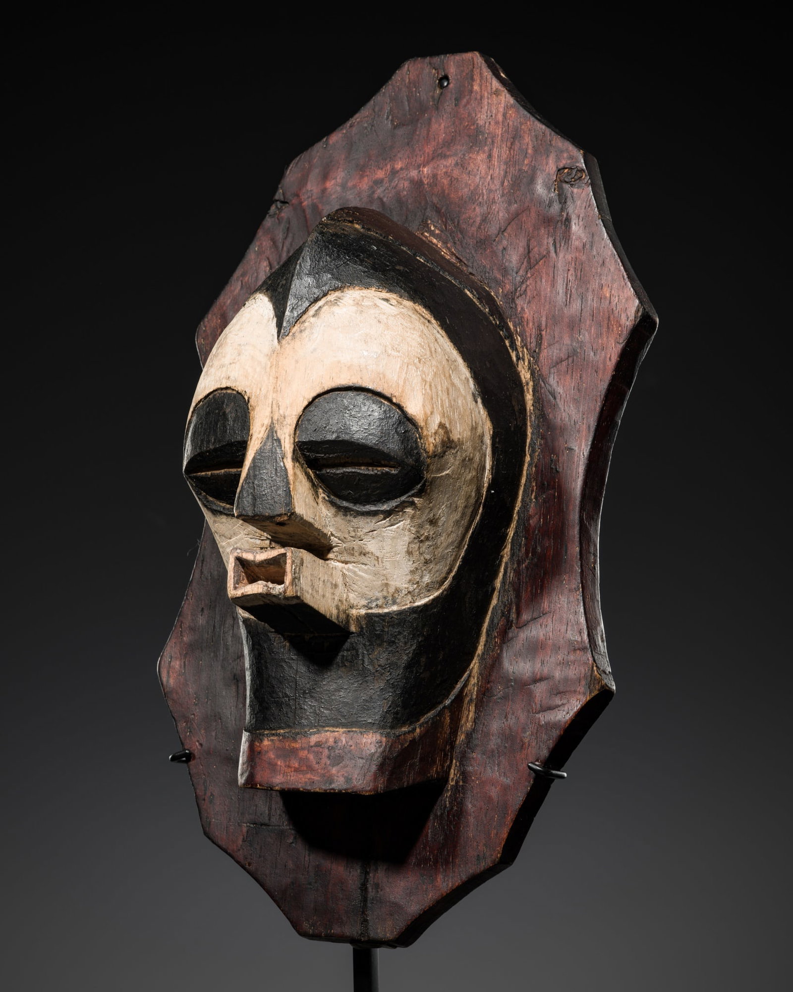 A SONGYE POLYCHROME WOOD SHIELD WITH A RITUAL MASK, KIFWEBE: A SONGYE POLYCHROME WOOD SHIELD WITH A RITUAL MASK, KIFWEBE Democratic Republic of the Congo, 20th century. Powerfully carved in a classical form and set on an elongated polygonal base with subtly con