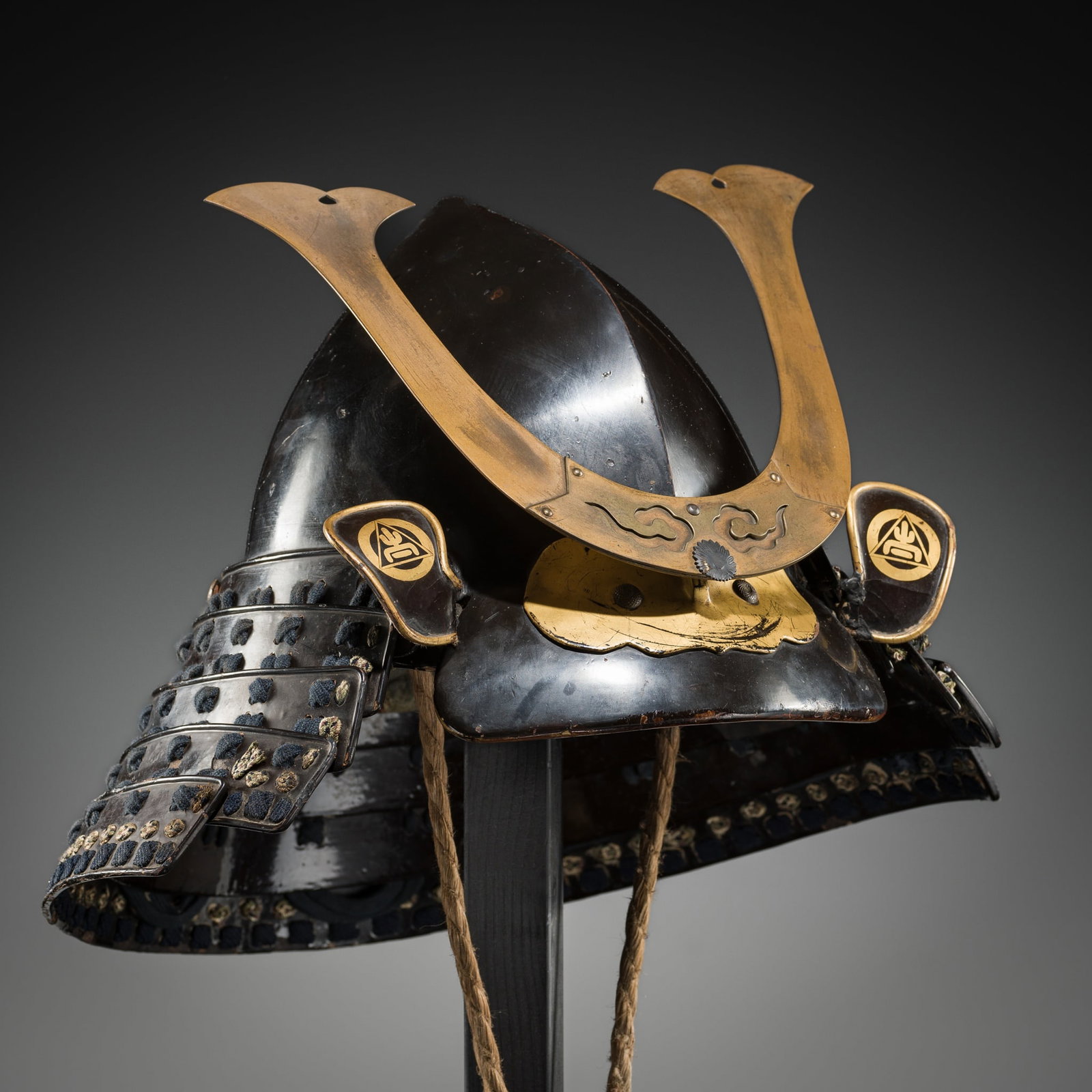 A RARE LACQUERED IRON MOMONARI KABUTO: A RARE LACQUERED IRON MOMONARI KABUTO Japan, 18th century, Edo period (1615-1868) The peach-shaped helmet lacquered black with a prominent central ridge, the tosei mabisashi (concave peak) fitted with