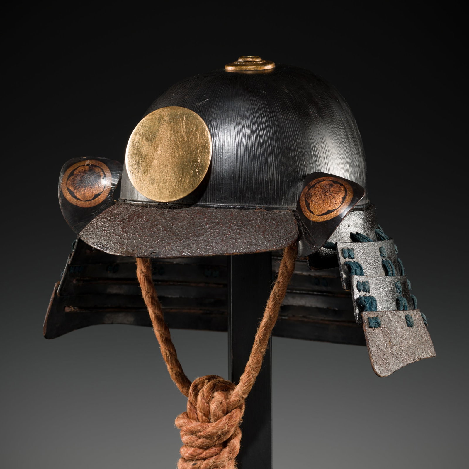 A LACQUERED NERIKAWA KABUTO WITH MATSUNAGA CLAN MON: A LACQUERED NERIKAWA KABUTO WITH MATSUNAGA CLAN MON Japan, Edo period (1615–1868) The finely striated hachi formed from lacquered nerikawa (hardened leather) and surmounted by a three-stage gilt
