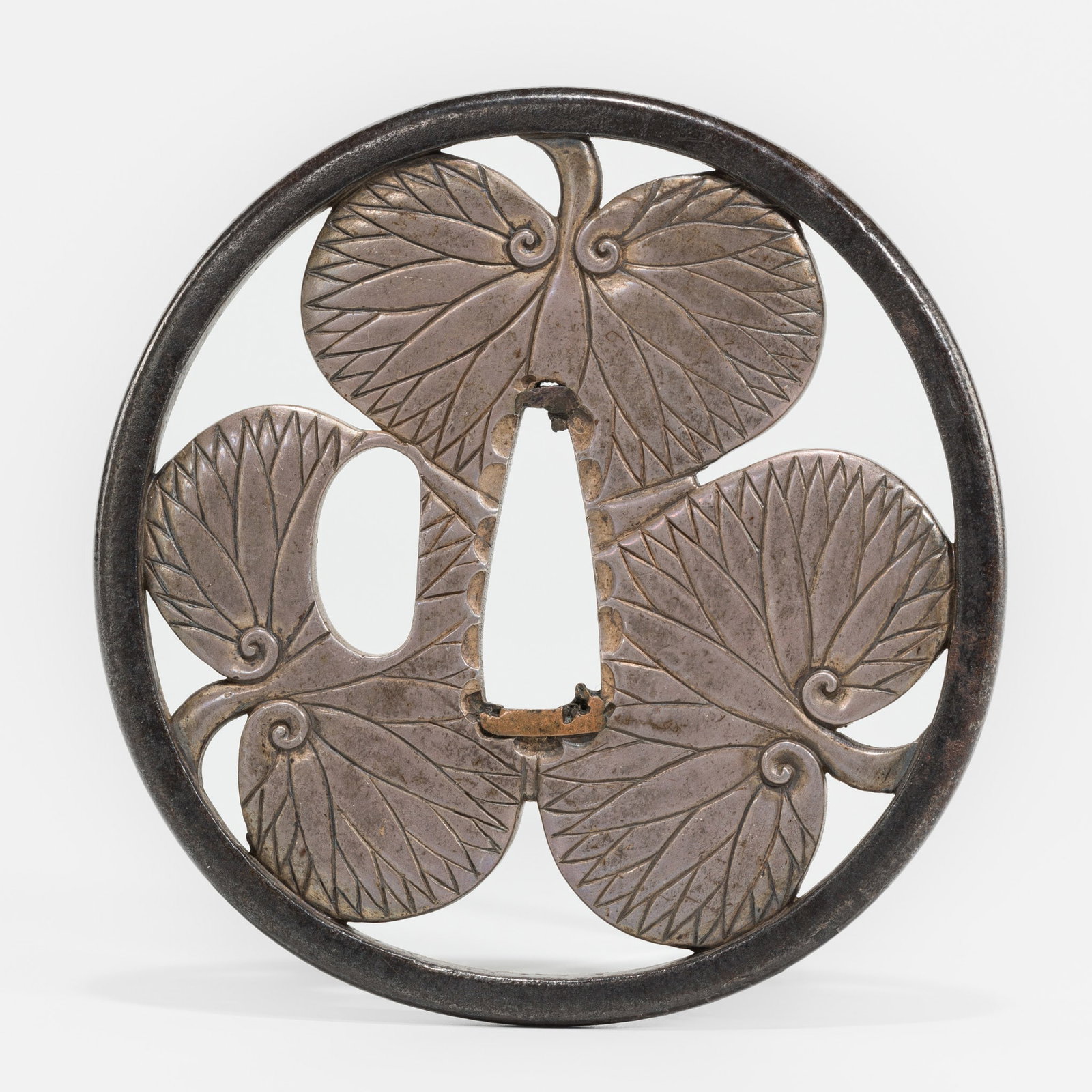 A FINE IRON AND SHIBUICHI SUKASHI TSUBA IN THE FORM OF AN AOI MON (1 of 4)