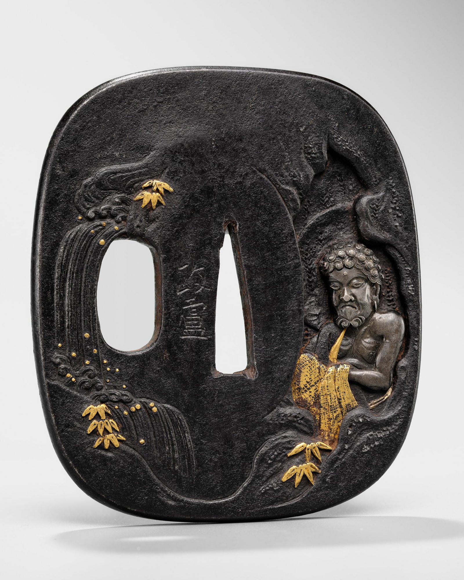 MASAYOSHI: AN IWAMA SCHOOL IRON TSUBA WITH SHAKA NYORAI IN MEDITATION: MASAYOSHI: AN IWAMA SCHOOL IRON TSUBA WITH SHAKA NYORAI IN MEDITATION By Masayoshi, signed Masayoshi 政蘆 Japan, Iwama school, 19th century, Edo period (1615-1868) Of kakumarugata form, wi