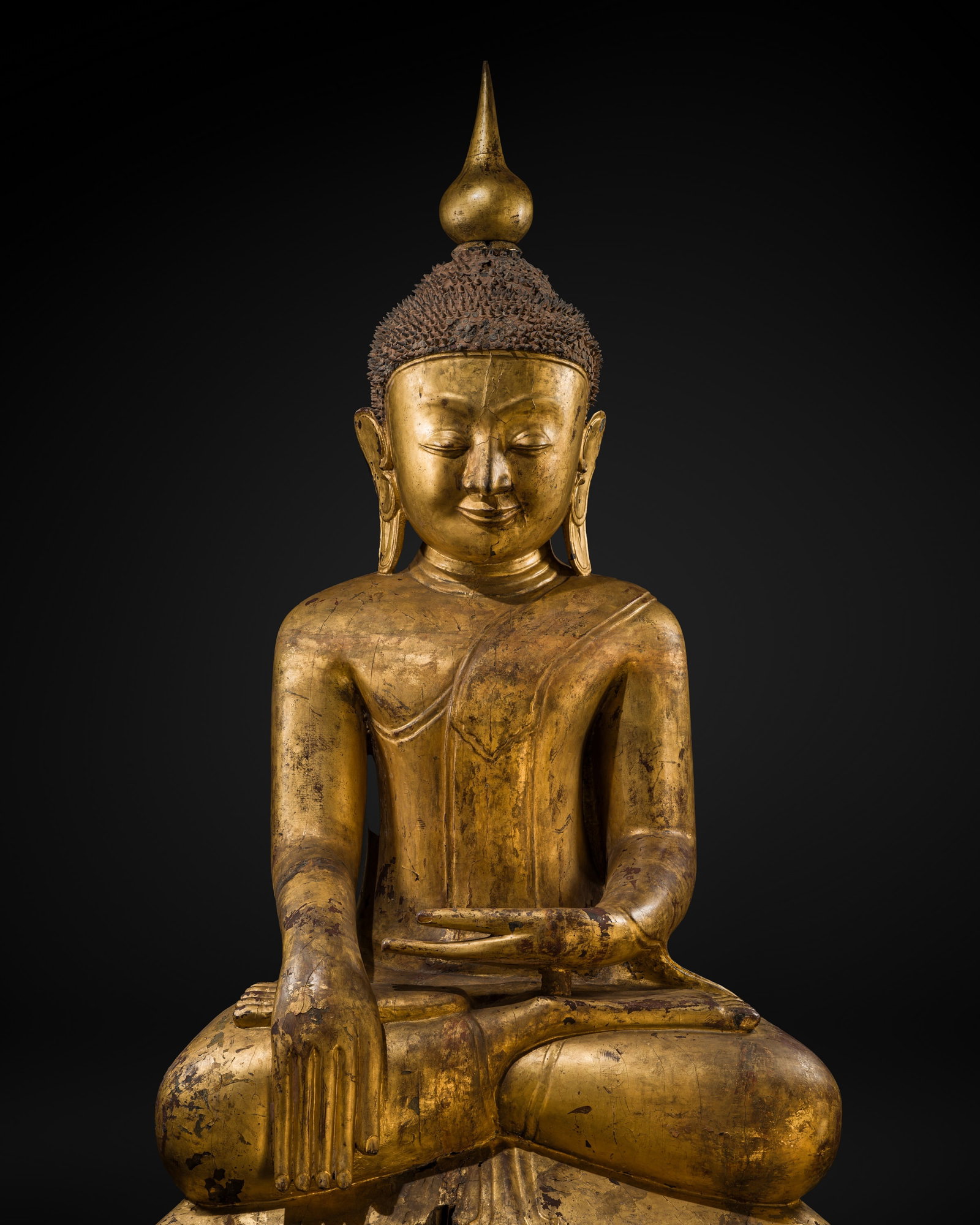 A MONUMENTAL (214 CM) GILT-LACQUERED WOOD STATUE OF BUDDHA SHAKYAMUNI, SHAN STATES, 17TH CENTURY: A MONUMENTAL (214 CM) GILT-LACQUERED WOOD STATUE OF BUDDHA SHAKYAMUNI, SHAN STATES, 17TH CENTURY This lot is from a single owner collection and is therefore offered without reserve The Jorgen Ruben Ga