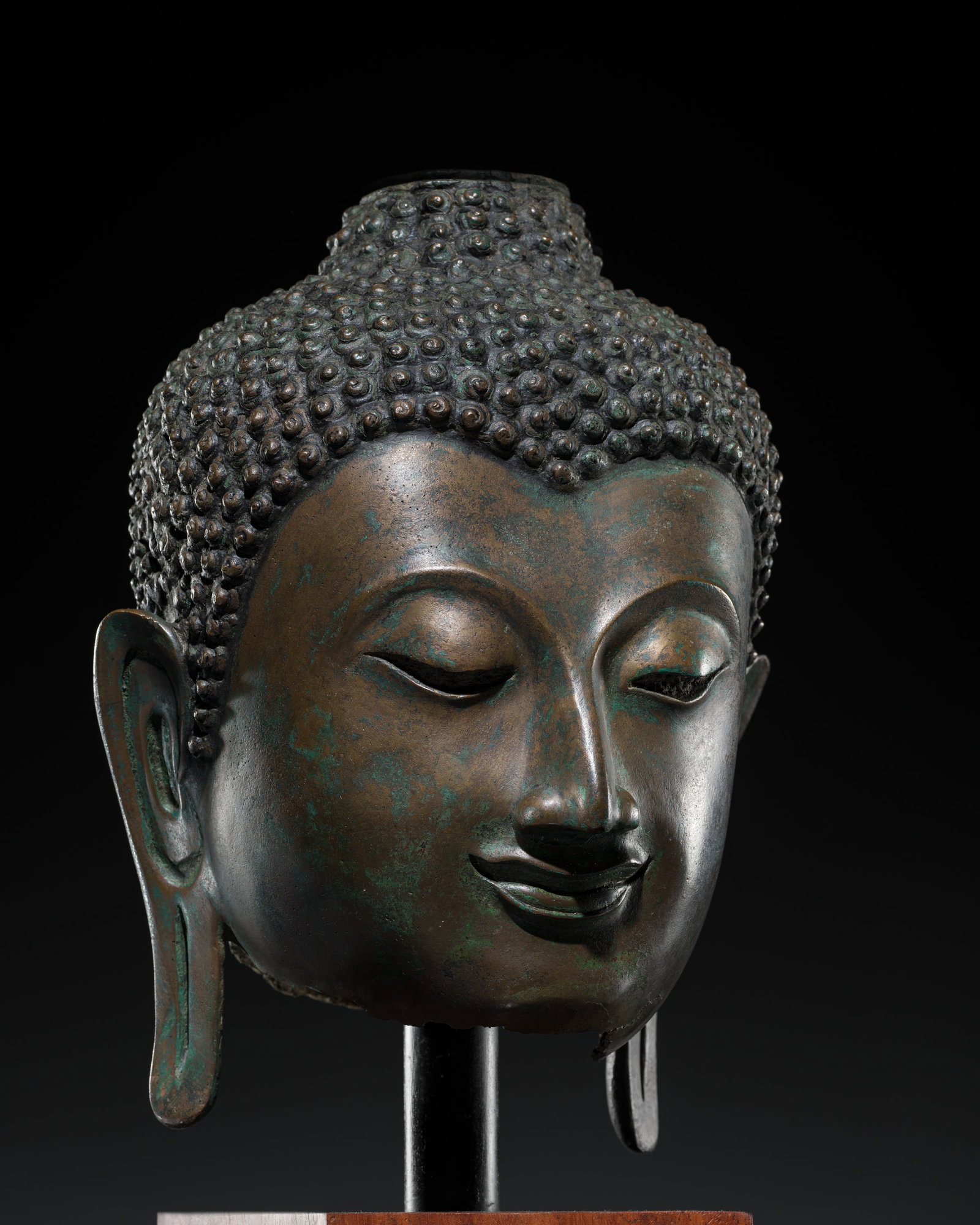 A LARGE BRONZE HEAD OF BUDDHA, SUKHOTHAI PERIOD, KAMPHAENG PHET STYLE, 15TH CENTURY: A LARGE BRONZE HEAD OF BUDDHA, SUKHOTHAI PERIOD, KAMPHAENG PHET STYLE, 15TH CENTURY This lot is from a single owner collection and is therefore offered without reserve The Jorgen Ruben Gallery Ledger,