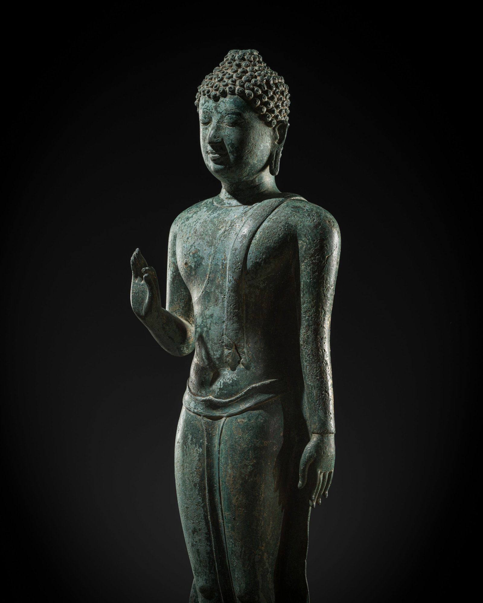 A RARE AND LARGE BRONZE FIGURE OF THE WALKING BUDDHA, CHIENG SEN PERIOD, 15TH CENTURY: A RARE AND LARGE BRONZE FIGURE OF THE WALKING BUDDHA, CHIENG SEN PERIOD, 15TH CENTURY This lot is from a single owner collection and is therefore offered without reserve The Jorgen Ruben Gallery Ledge