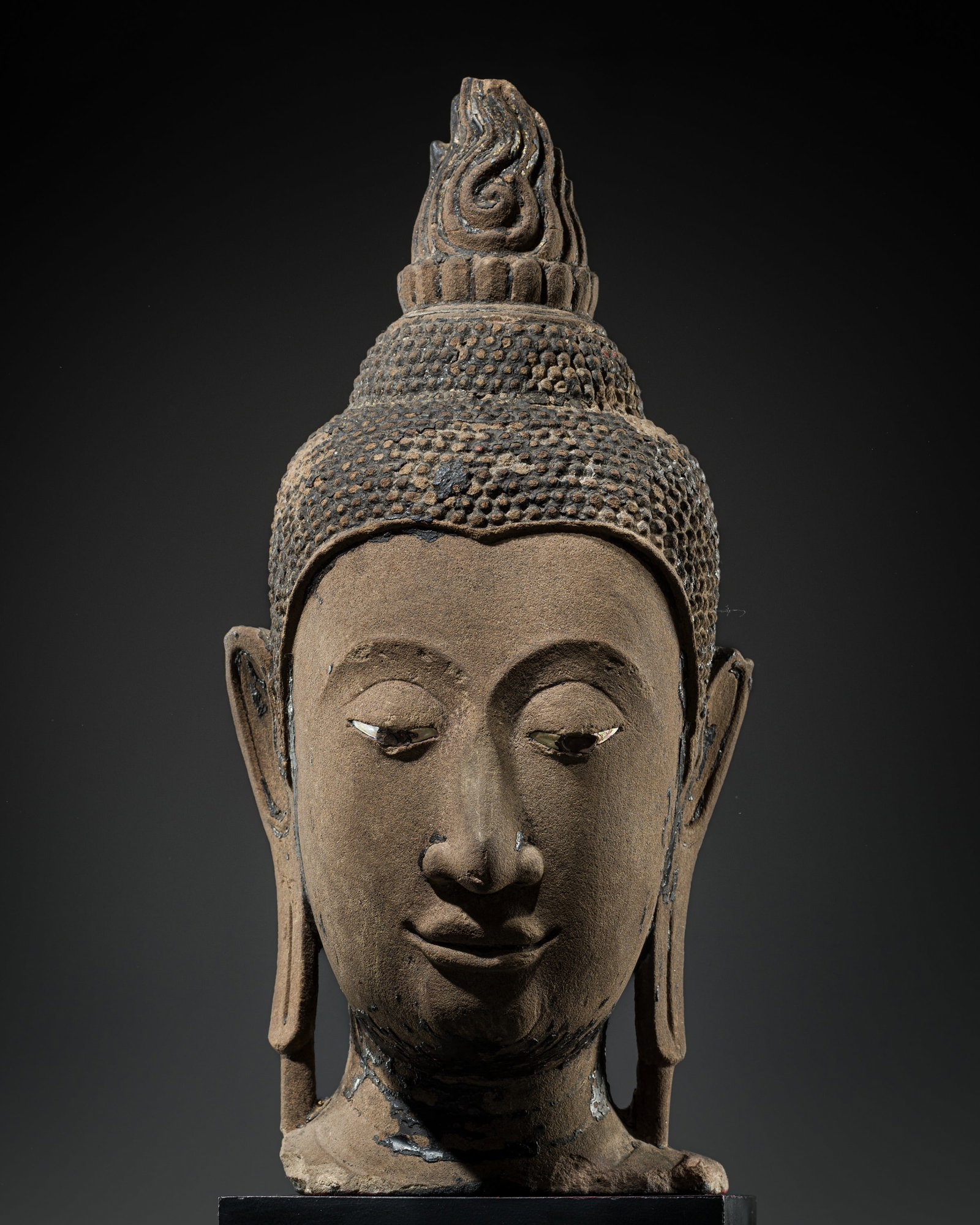 A MONUMENTAL SANDSTONE HEAD OF BUDDHA, AYUTTHAYA KINGDOM, 15TH CENTURY: A MONUMENTAL SANDSTONE HEAD OF BUDDHA, AYUTTHAYA KINGDOM, 15TH CENTURY This lot is from a single owner collection and is therefore offered without reserve Thailand. The exquisitely modeled face bears 