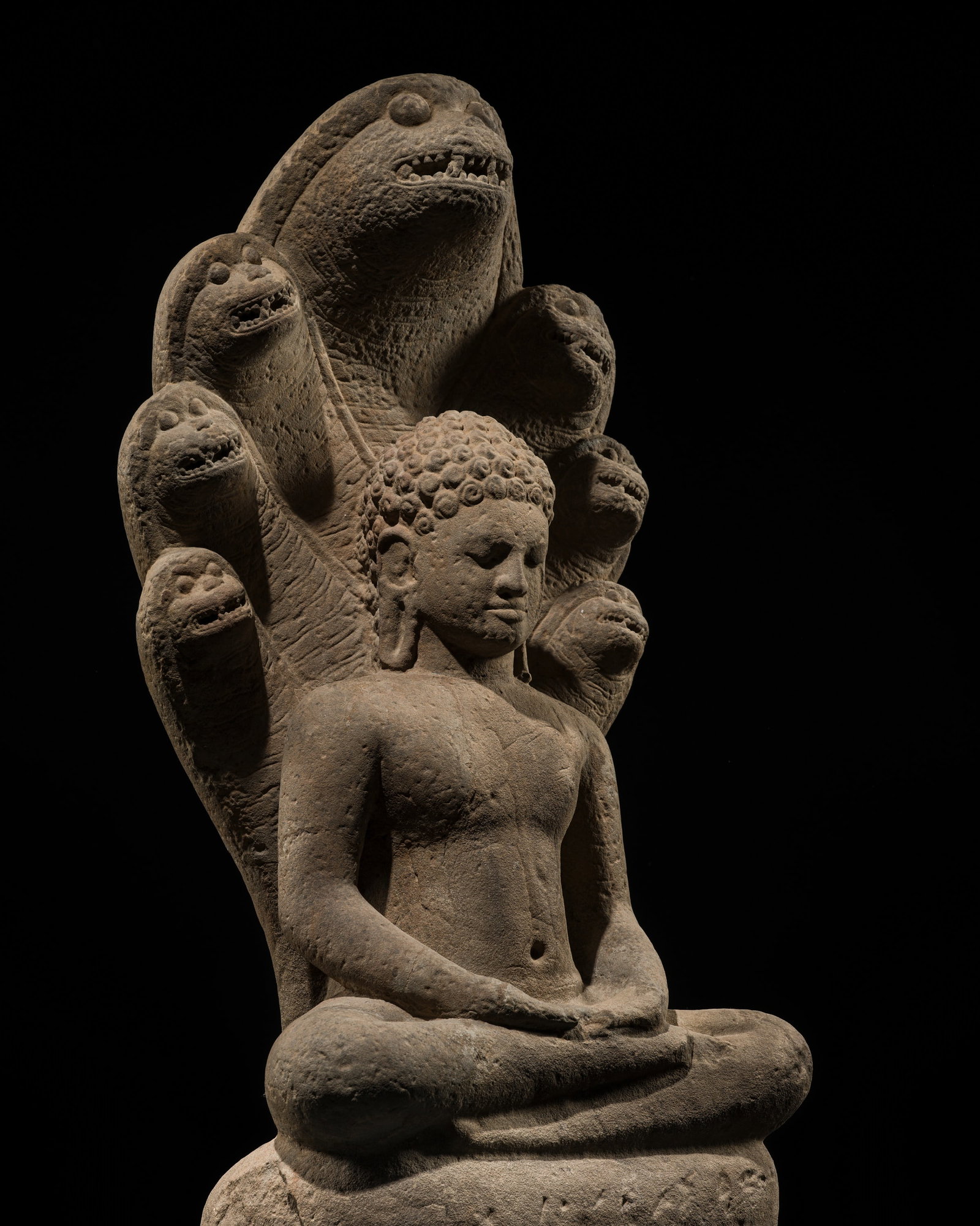 A RARE AND IMPORTANT SANDSTONE FIGURE OF BUDDHA MUCHALINDA, ANGKOR BOREI STYLE, PRE-ANGKOR PERIOD,: A RARE AND IMPORTANT SANDSTONE FIGURE OF BUDDHA MUCHALINDA, ANGKOR BOREI STYLE, PRE-ANGKOR PERIOD, 7TH CENTURY This lot is from a single owner collection and is therefore offered without reserve The J