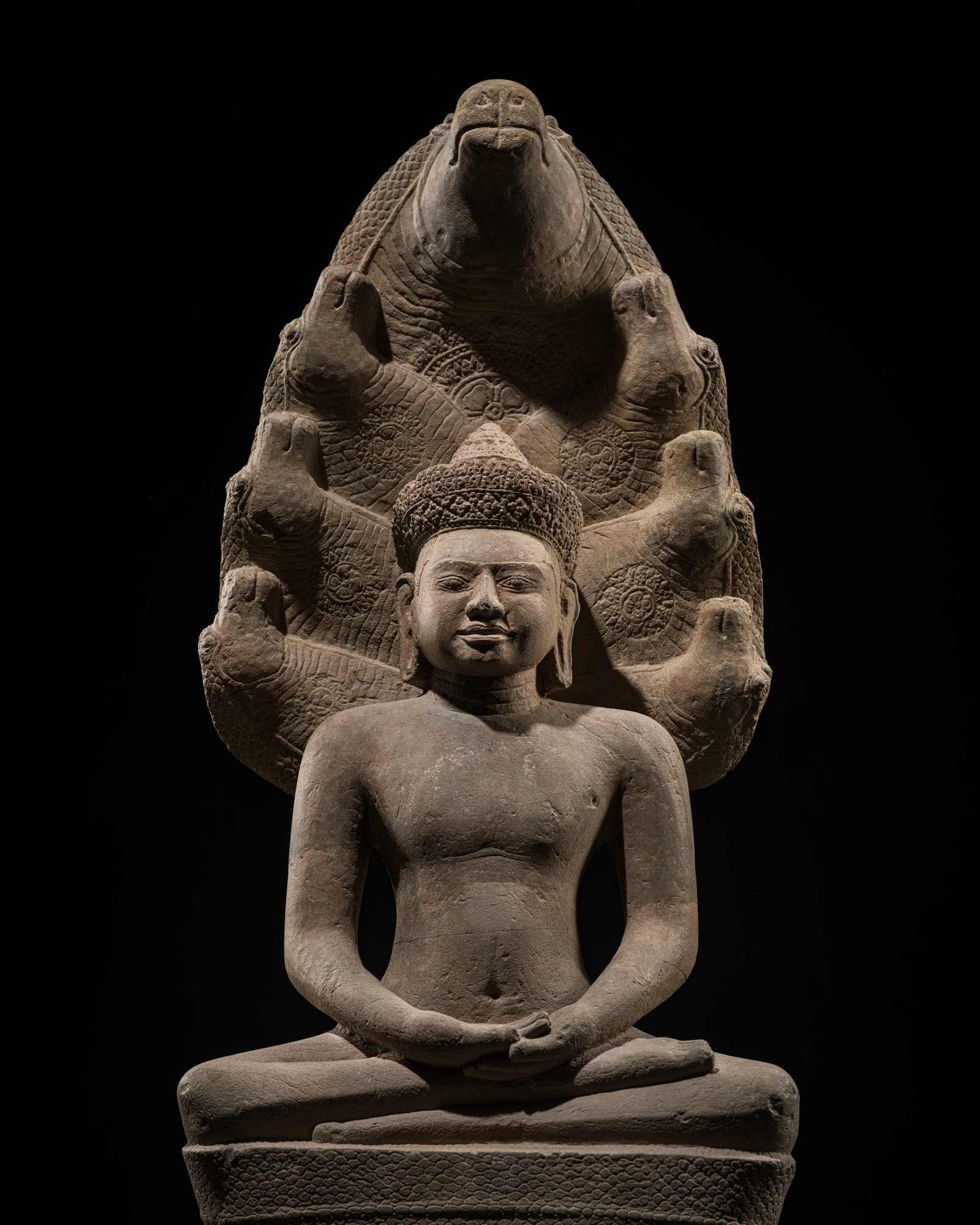 A LARGE SANDSTONE FIGURE OF BUDDHA MUCHALINDA, ANGKOR WAT STYLE, 12TH CENTURY: A LARGE SANDSTONE FIGURE OF BUDDHA MUCHALINDA, ANGKOR WAT STYLE, 12TH CENTURY This lot is from a single owner collection and is therefore offered without reserve Khmer Empire, Cambodia. Magnificently 