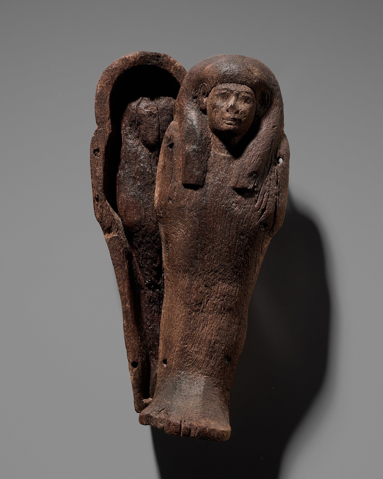 AN EGYPTIAN WOOD SHABTI WITH A FITTED WOOD ANTHROPOID COFFIN, NEW KINGDOM, DYNASTY XVIII-XIX: AN EGYPTIAN WOOD SHABTI WITH A FITTED WOOD ANTHROPOID COFFIN, NEW KINGDOM, DYNASTY XVIII-XIX This lot is from a single owner collection and is therefore offered without reserve The Jorgen Ruben Galler