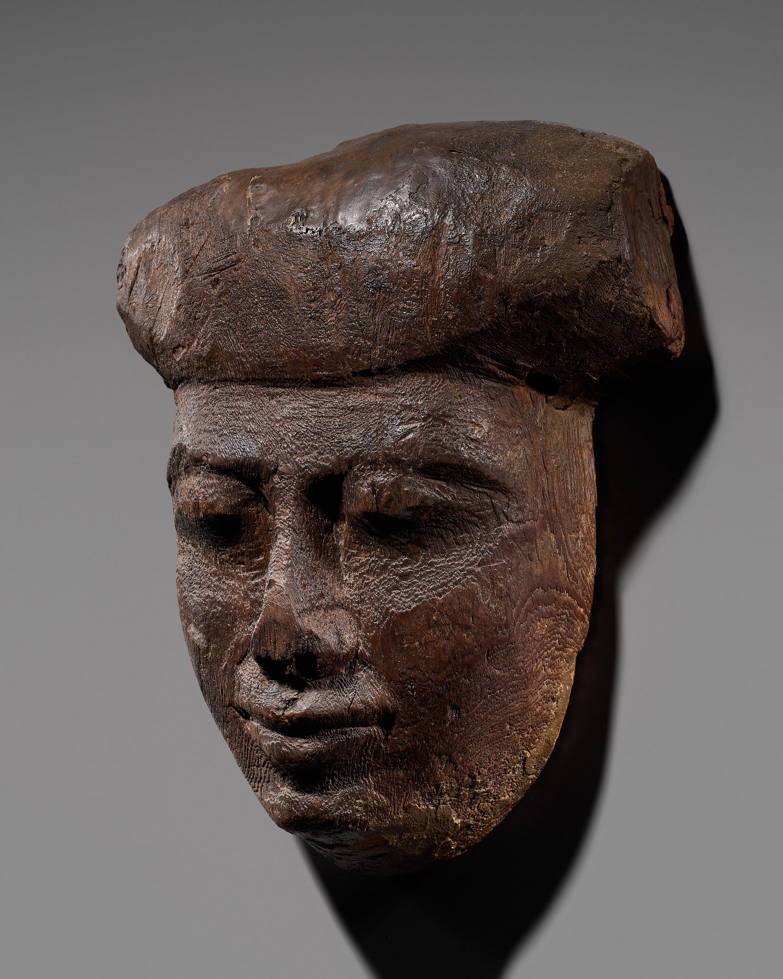AN EGYPTIAN WOOD SARCOPHAGUS MASK, LATE PERIOD: AN EGYPTIAN WOOD SARCOPHAGUS MASK, LATE PERIOD This lot is from a single owner collection and is therefore offered without reserve The Jorgen Ruben Gallery Ledger, entry from 2005: “No. 76, JS, 