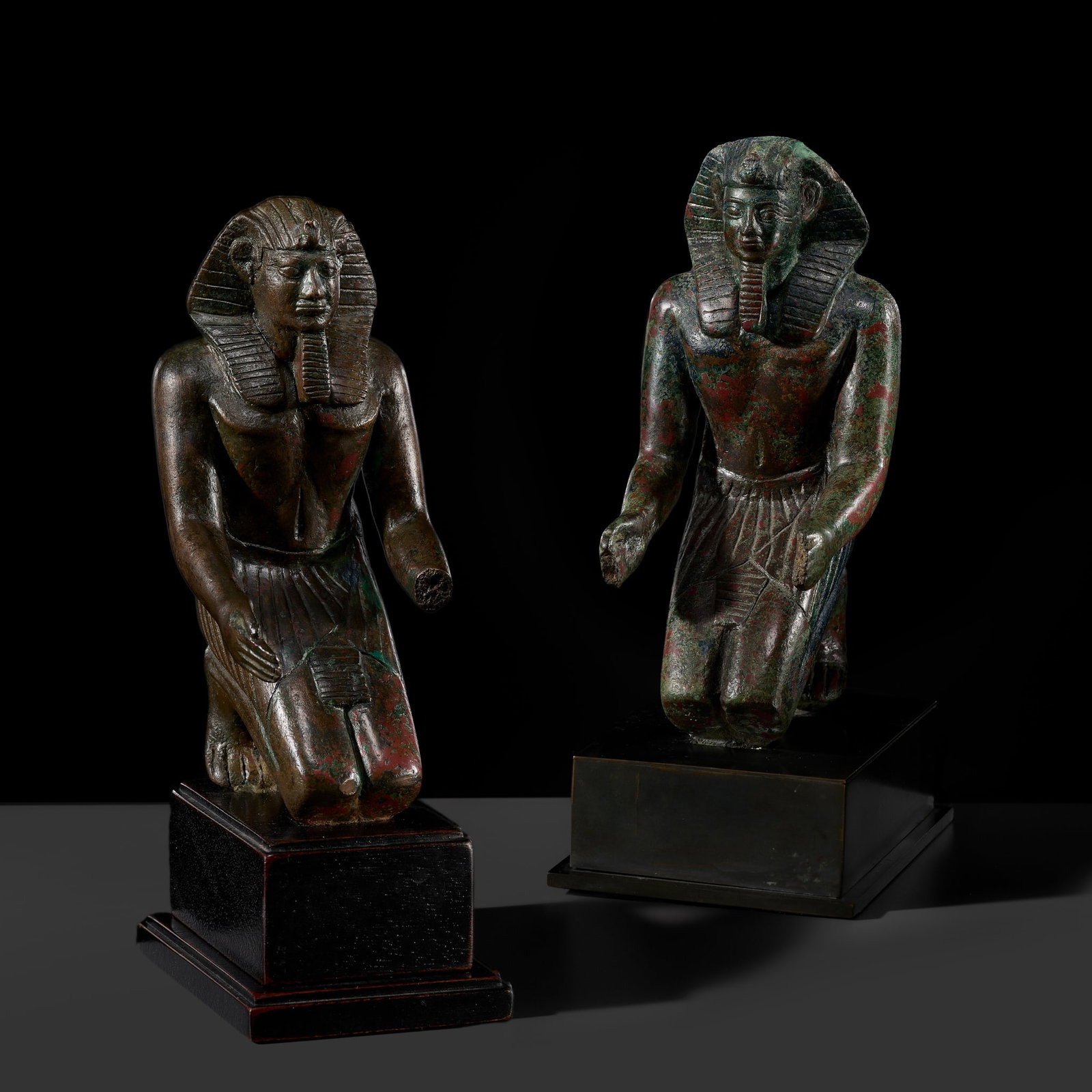 A RARE PAIR OF EGYPTIAN BRONZE FIGURES OF KNEELING PHARAOHS, PTOLEMAIC PERIOD: A RARE PAIR OF EGYPTIAN BRONZE FIGURES OF KNEELING PHARAOHS, PTOLEMAIC PERIOD This lot is from a single owner collection and is therefore offered without reserve The Jorgen Ruben Gallery Ledger, entry