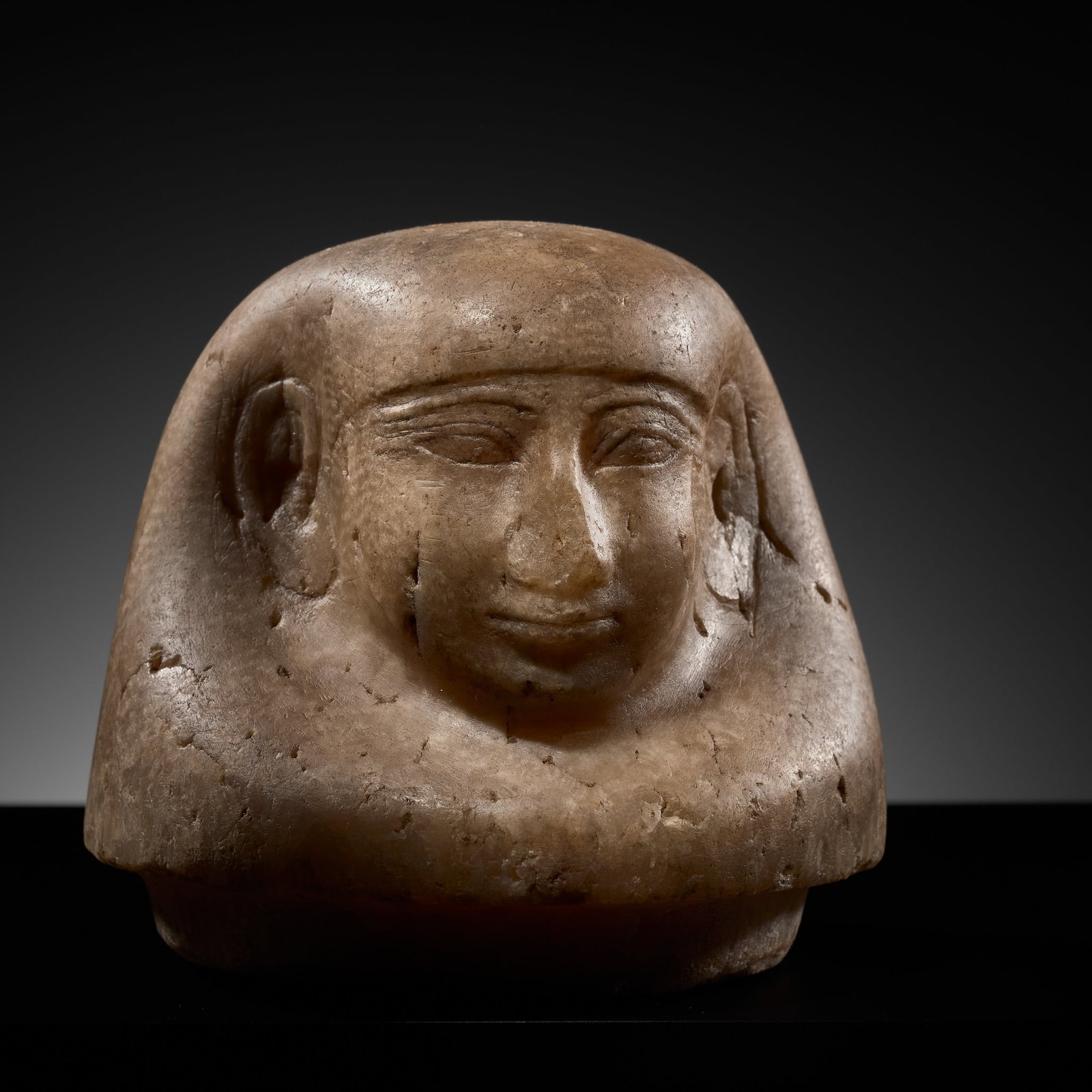 AN EGYPTIAN ALABASTER 'IMSETY' CANOPIC JAR HEAD, NEW KINGDOM-LATE PERIOD, DYNASTY XVIII-XXVI: AN EGYPTIAN ALABASTER 'IMSETY' CANOPIC JAR HEAD, NEW KINGDOM-LATE PERIOD, DYNASTY XVIII-XXVI This lot is from a single owner collection and is therefore offered without reserve The Jorgen Ruben Galler