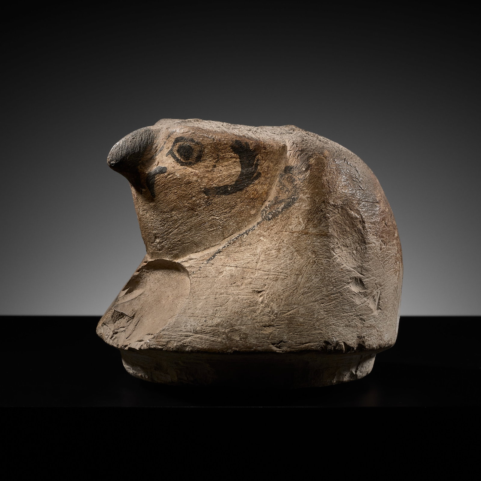 AN EGYPTIAN PAINTED LIMESTONE 'QEBEHSENUEF' CANOPIC JAR HEAD, LATE PERIOD: AN EGYPTIAN PAINTED LIMESTONE 'QEBEHSENUEF' CANOPIC JAR HEAD, LATE PERIOD This lot is from a single owner collection and is therefore offered without reserve Egypt, 664-332 BC. The lid carved in the f