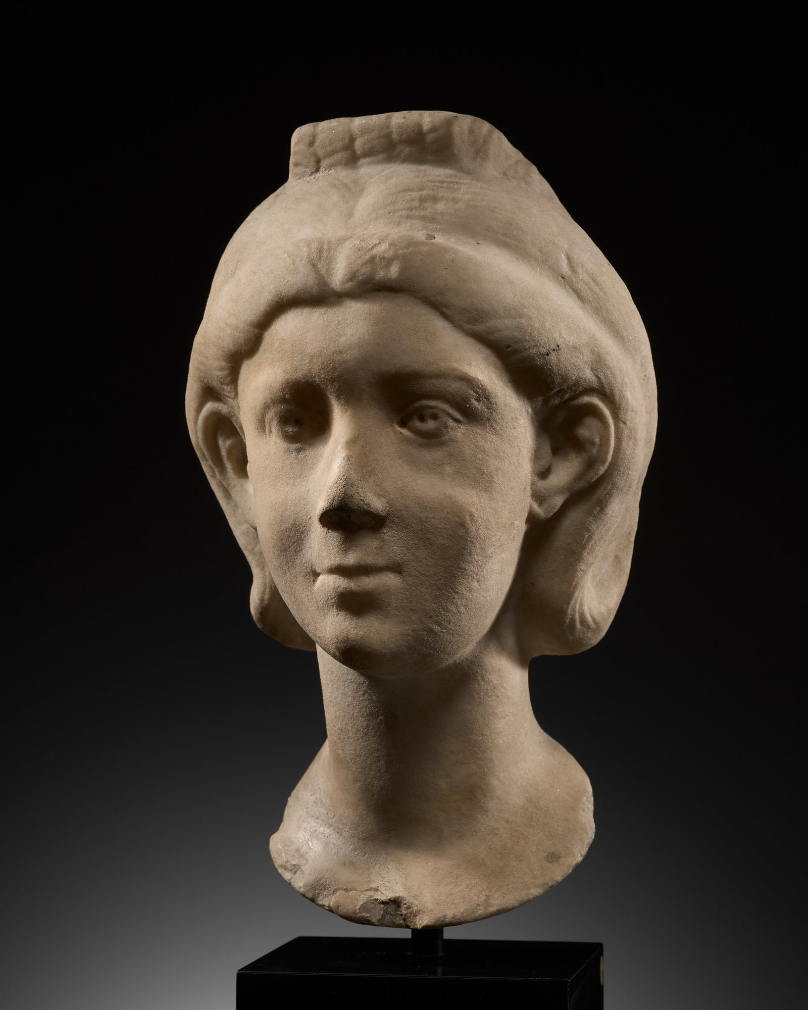 A ROMAN MARBLE PORTRAIT HEAD OF A YOUNG WOMAN, CIRCA 220-240: A ROMAN MARBLE PORTRAIT HEAD OF A YOUNG WOMAN, CIRCA 220-240 This lot is from a single owner collection and is therefore offered without reserve Superbly carved with sharp cheekbones and a pointed chi