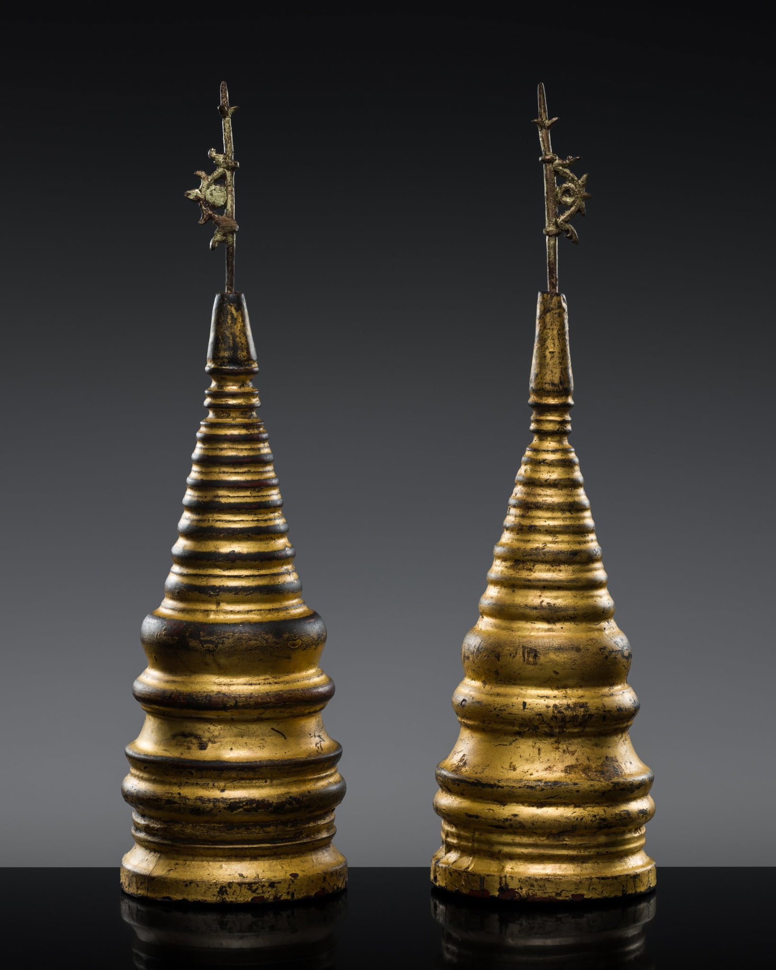 A PAIR OF UNUSUAL BURMESE LACQUER GILT WOOD STUPAS WITH BRONZE FINIALS, 18TH-19TH CENTURY: A PAIR OF UNUSUAL BURMESE LACQUER GILT WOOD STUPAS WITH BRONZE FINIALS, 18TH-19TH CENTURY This lot is from a single owner collection and is therefore offered without reserve The Jorgen Ruben Gallery L