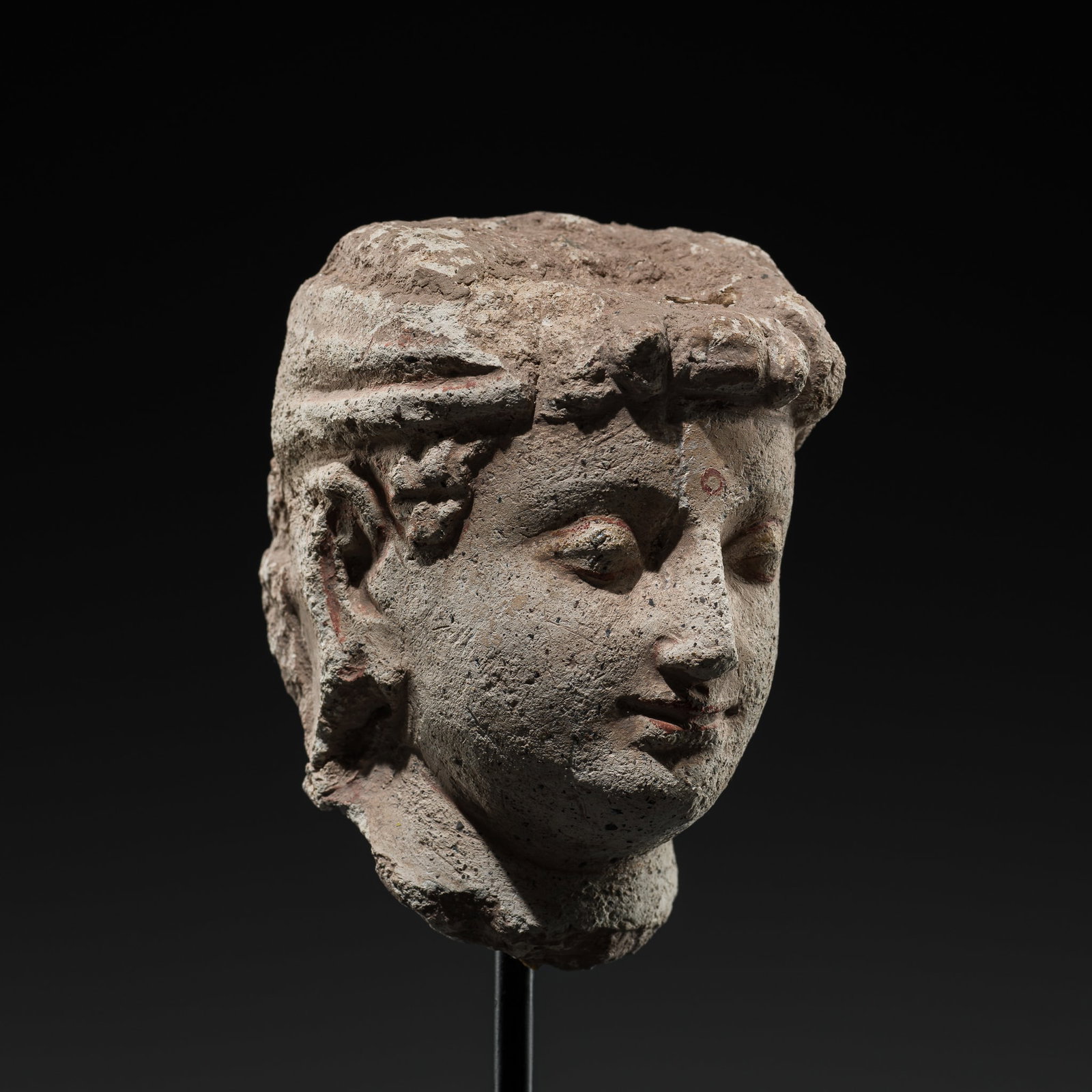 A STUCCO HEAD OF A BODHISATTVA, ANCIENT REGION OF GANDHARA, 3RD-4TH CENTURY: A STUCCO HEAD OF A BODHISATTVA, ANCIENT REGION OF GANDHARA, 3RD-4TH CENTURY This lot is from a single owner collection and is therefore offered without reserve The Jorgen Ruben Gallery Ledger, entry f