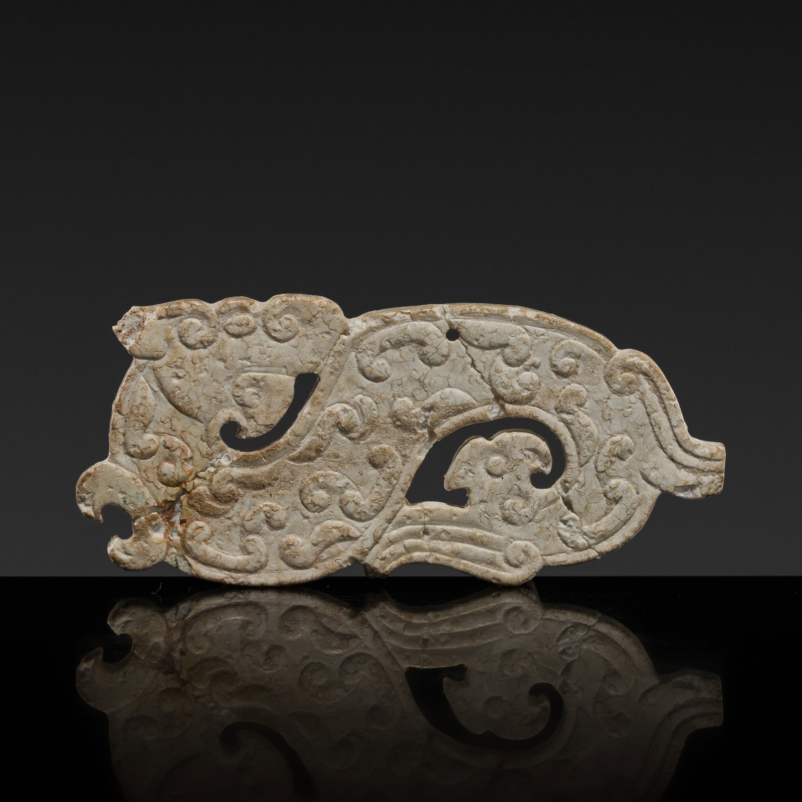 A JADE 'DRAGON' PENDANT, WARRING STATES PERIOD: A JADE 'DRAGON' PENDANT, WARRING STATES PERIOD This lot is from a single owner collection and is therefore offered without reserve The Jorgen Ruben Gallery Ledger, entry from 2012: “No. 704, Pla