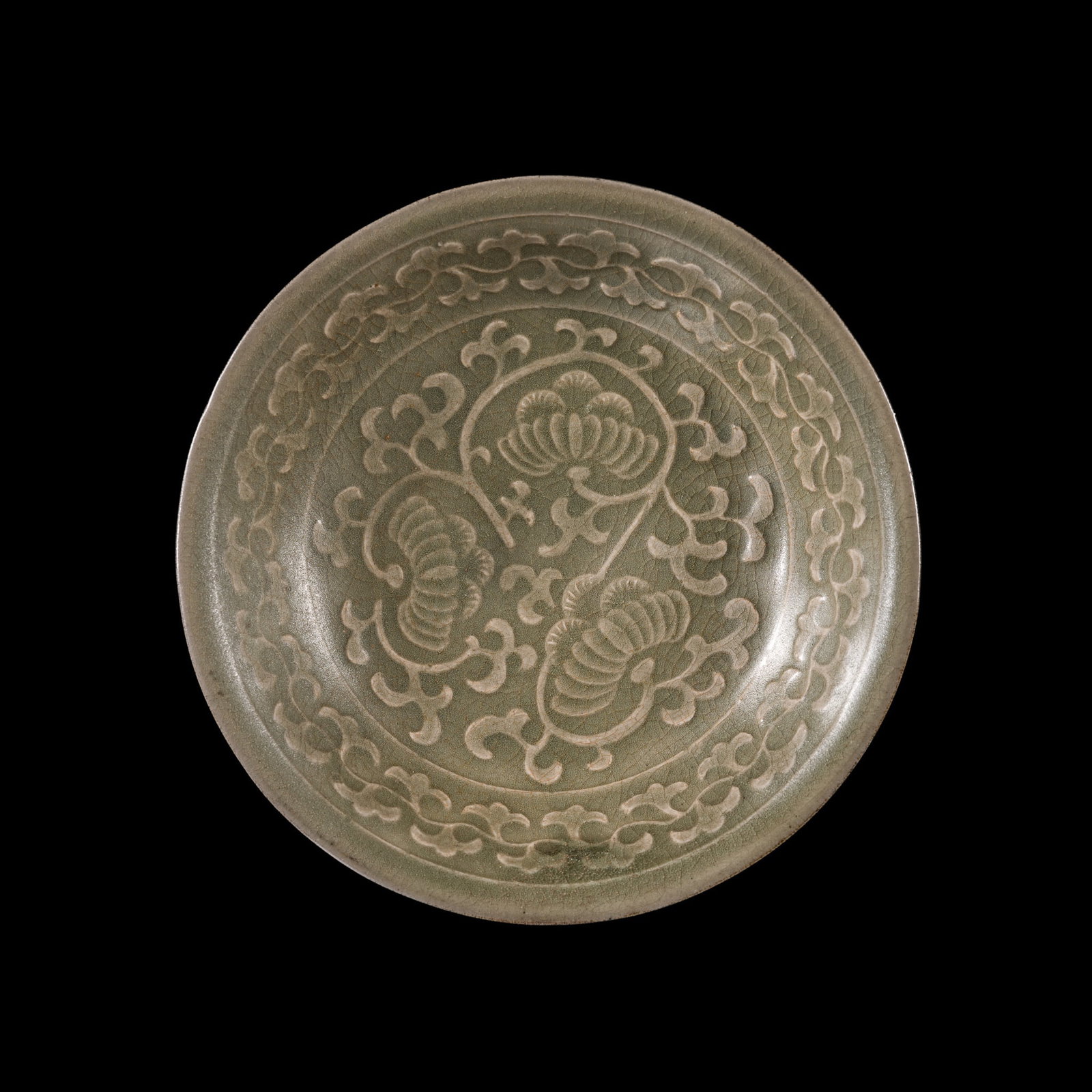 A MOLDED YAOZHOU CELADON 'CHRYSANTHEMUM' DISH, SONG DYNASTY: A MOLDED YAOZHOU CELADON 'CHRYSANTHEMUM' DISH, SONG DYNASTY This lot is from a single owner collection and is therefore offered without reserve China, 12th century. Finely potted with shallow rounded 