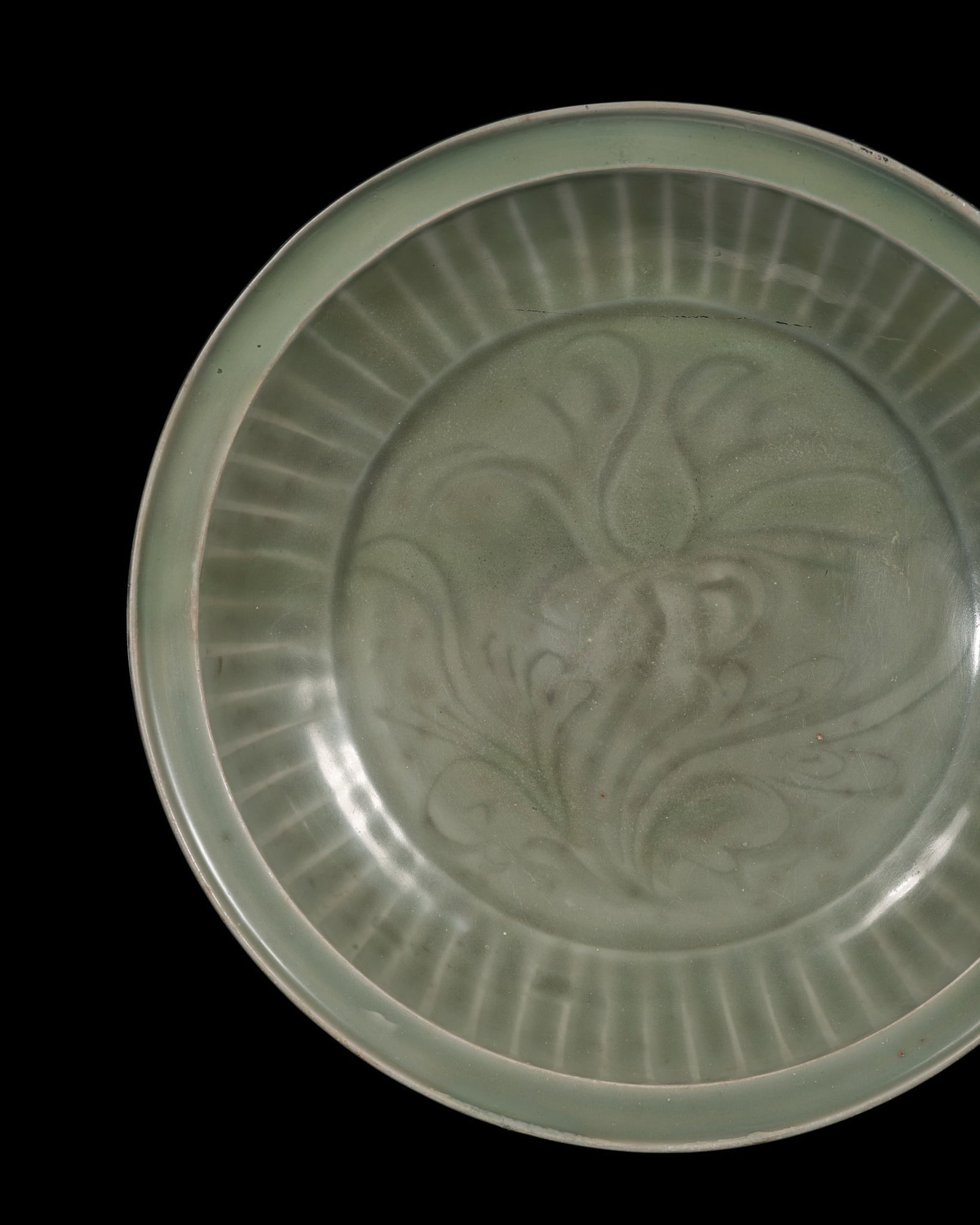 A CARVED 'LOTUS' LONGQUAN CELADON DISH, YUAN DYNASTY: A CARVED 'LOTUS' LONGQUAN CELADON DISH, YUAN DYNASTY This lot is from a single owner collection and is therefore offered without reserve China, 1279-1368. Heavily potted with rounded sides rising from