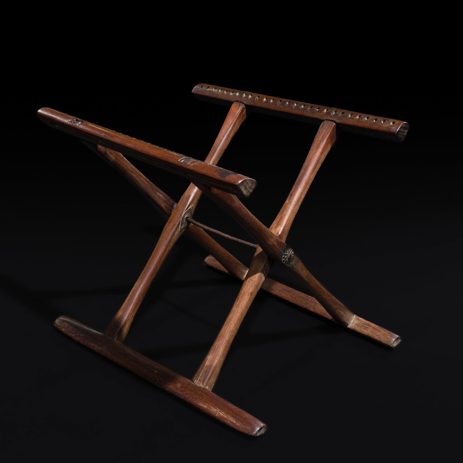 A HARDWOOD FOLDING STOOL, QING DYNASTY: A HARDWOOD FOLDING STOOL, QING DYNASTY This lot is from a single owner collection and is therefore offered without reserve China, 1644-1912. The rounded X-form legs joined by a central metal pivot, al