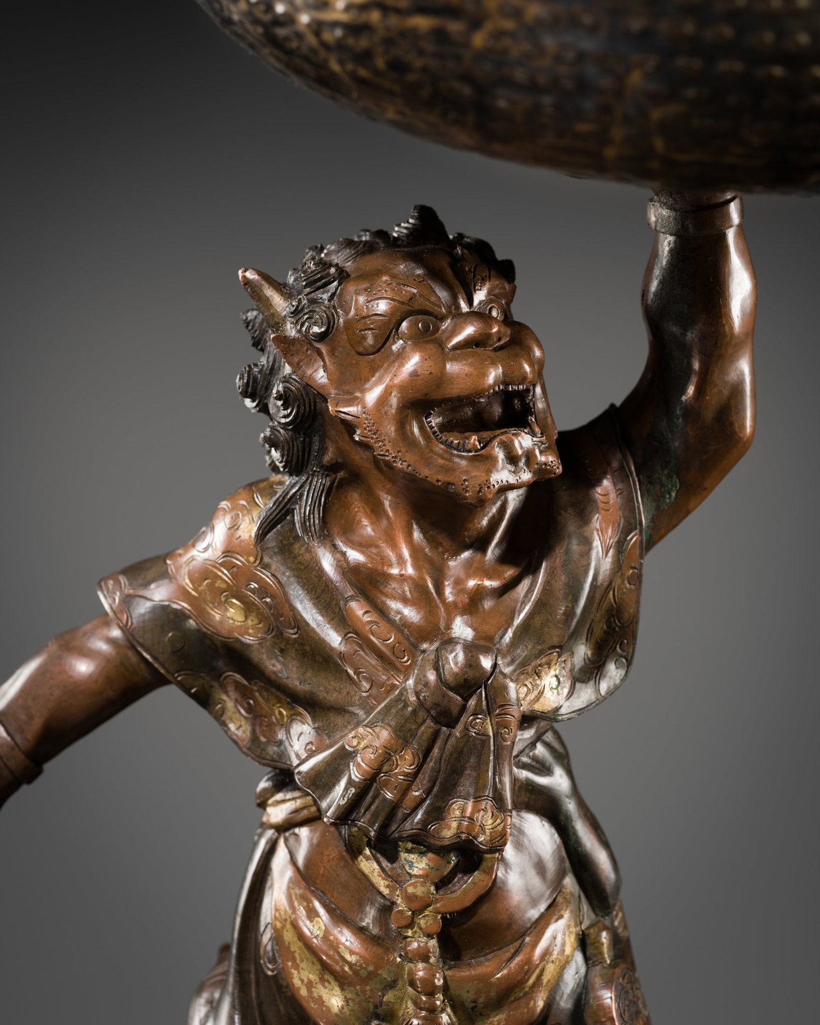 A PARCEL-GILT BRONZE FIGURE OF AN ONI HOLDING ALOFT A SOUND BOWL, MIYAO STYLE, MEIJI PERIOD: A PARCEL-GILT BRONZE FIGURE OF AN ONI HOLDING ALOFT A SOUND BOWL, MIYAO STYLE, MEIJI PERIOD This lot is from a single owner collection and is therefore offered without reserve Japan, 1868-1912. The de
