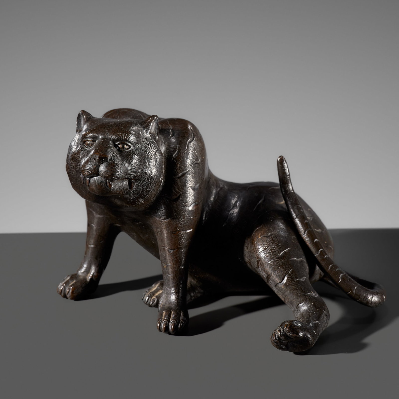 A BRONZE OKIMONO OF A TIGER, BY KAKUUNSAI, MEIJI PERIOD, LATE 19TH CENTURY: A BRONZE OKIMONO OF A TIGER, BY KAKUUNSAI, MEIJI PERIOD, LATE 19TH CENTURY This lot is from a single owner collection and is therefore offered without reserve Japan. Finely cast seated on its haunches