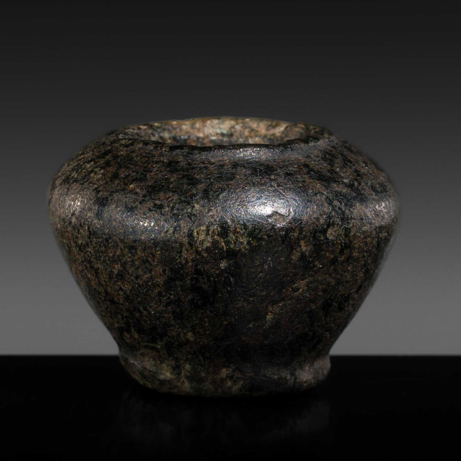 AN EGYPTIAN BASALT COSMETIC KOHL POT, OLD KINGDOM: AN EGYPTIAN BASALT COSMETIC KOHL POT, OLD KINGDOM This lot is from a single owner collection and is therefore offered without reserve Egypt, c. 2686-2181 BC. Well carved, the globular body tapering ge