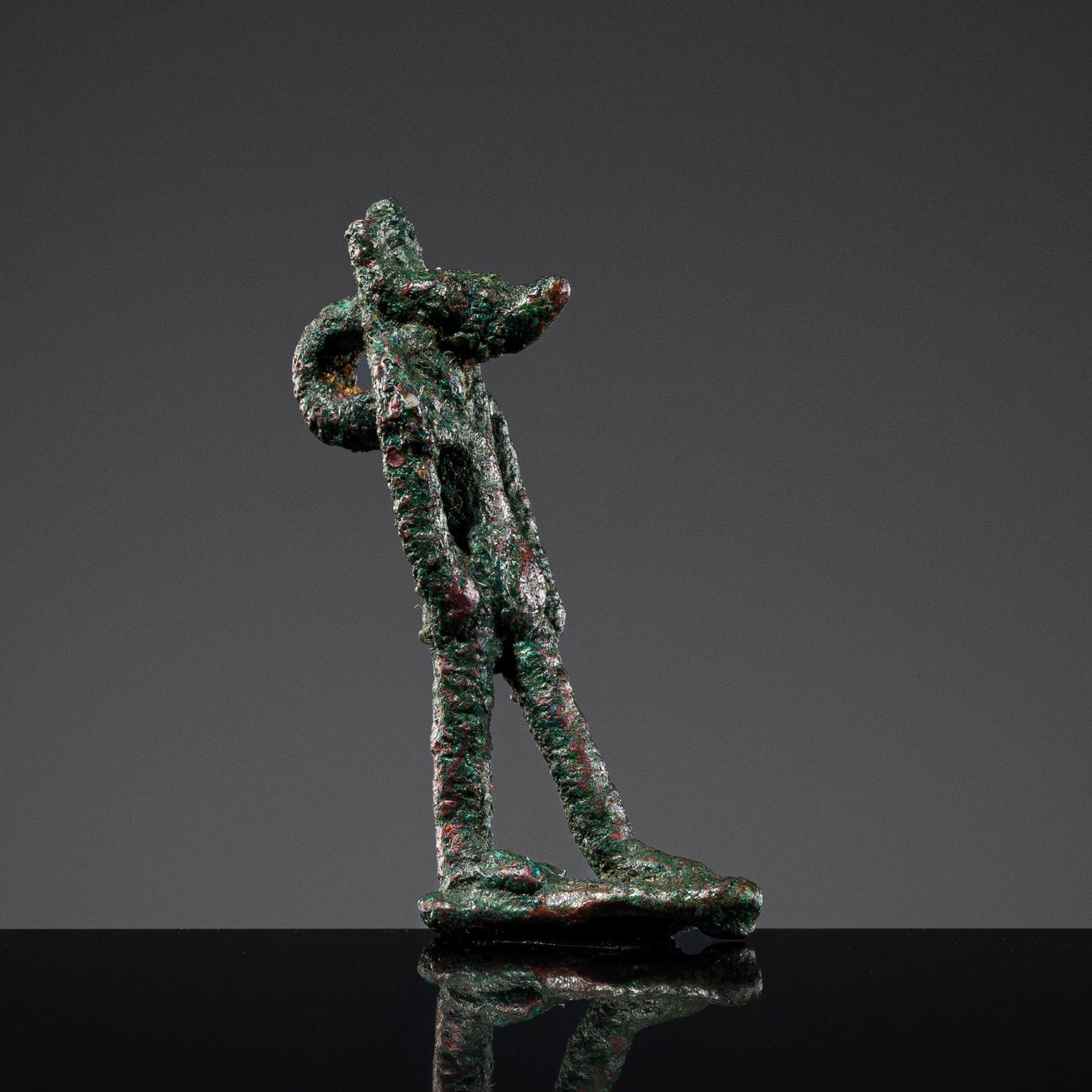 A BRONZE AMULET OF ANUBIS, LATE PERIOD: A BRONZE AMULET OF ANUBIS, LATE PERIOD This lot is from a single owner collection and is therefore offered without reserve Egypt, 664-332 BC. The jackal-headed god of embalming is depicted striding fo