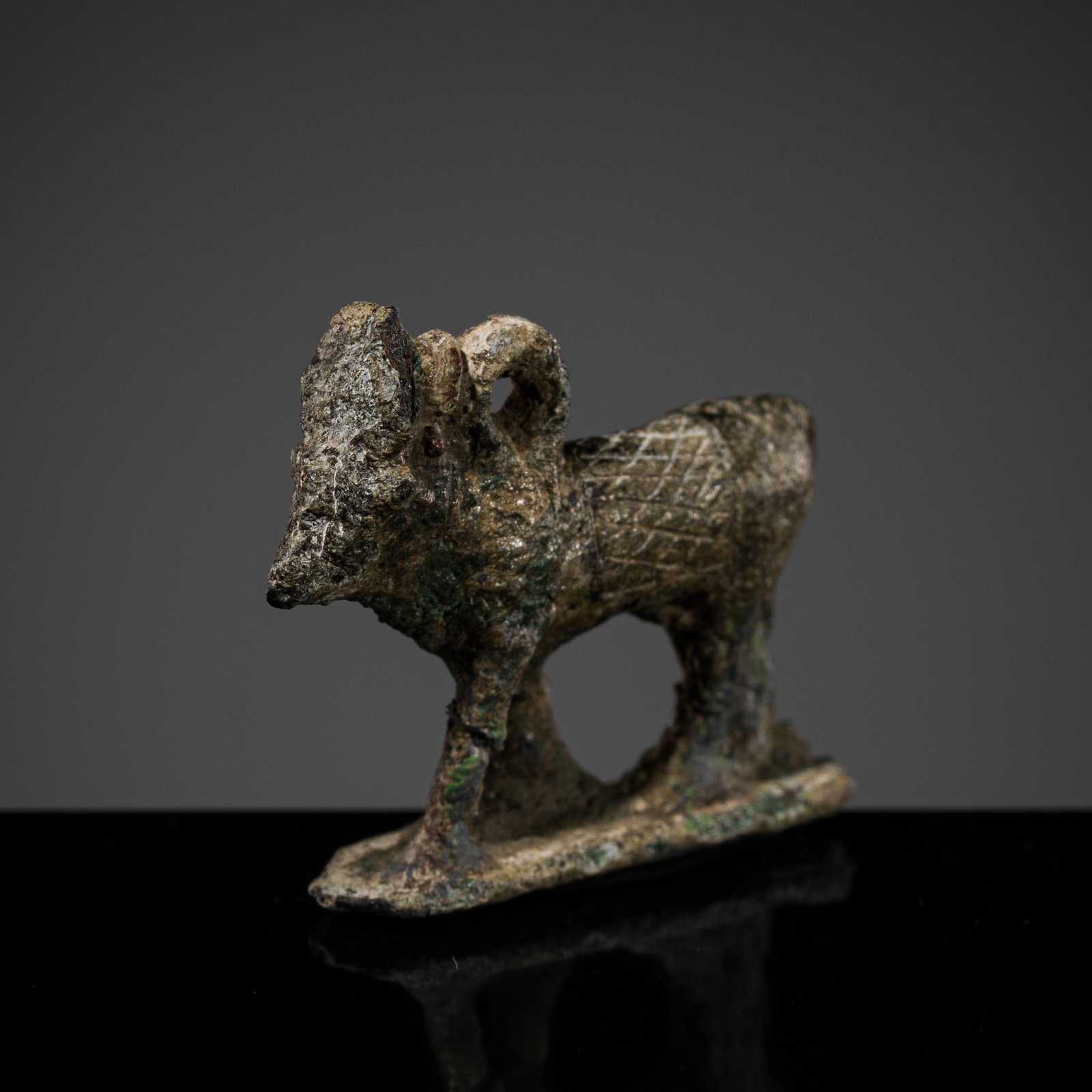 AN EGYPTIAN BRONZE 'APIS BULL' PENDANT, LATE PERIOD-PTOLEMAIC PERIOD: AN EGYPTIAN BRONZE 'APIS BULL' PENDANT, LATE PERIOD-PTOLEMAIC PERIOD This lot is from a single owner collection and is therefore offered without reserve Egypt, 664-30 BC. Skillfully cast, the animal d