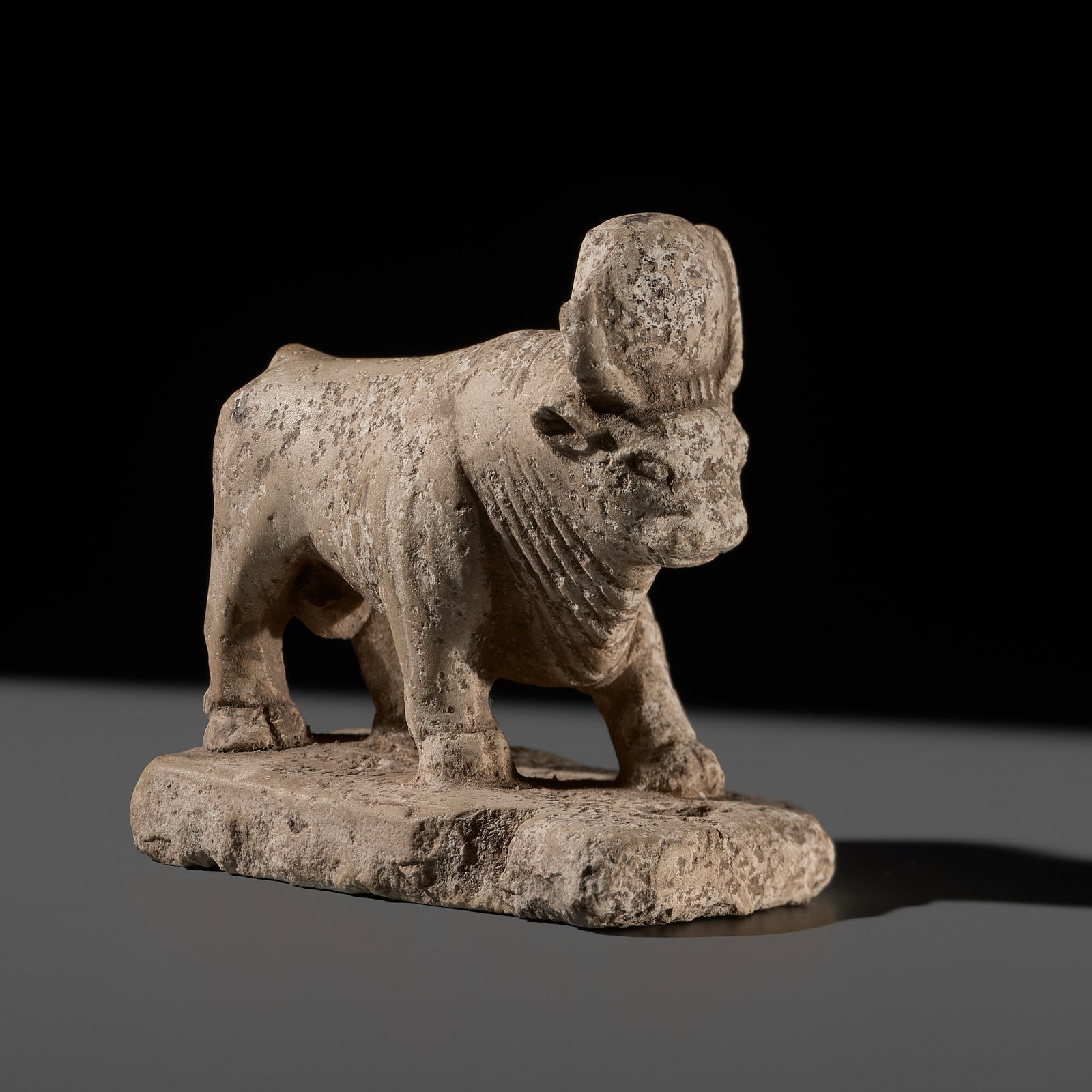 AN EGYPTIAN LIMESTONE FIGURE OF AN APIS BULL, LATE PERIOD (1 of 15)