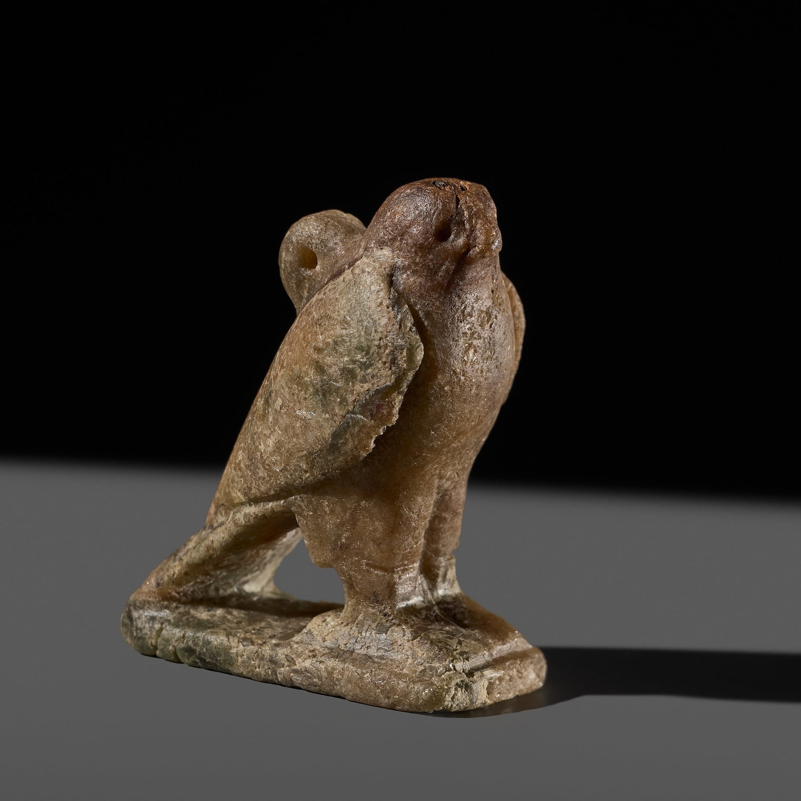 A RARE EGYPTIAN QUARTZITE 'HORUS FALCON' AMULET, LATE PERIOD: A RARE EGYPTIAN QUARTZITE 'HORUS FALCON' AMULET, LATE PERIOD This lot is from a single owner collection and is therefore offered without reserve The Jorgen Ruben Gallery Ledger, entry from 2012: ̶