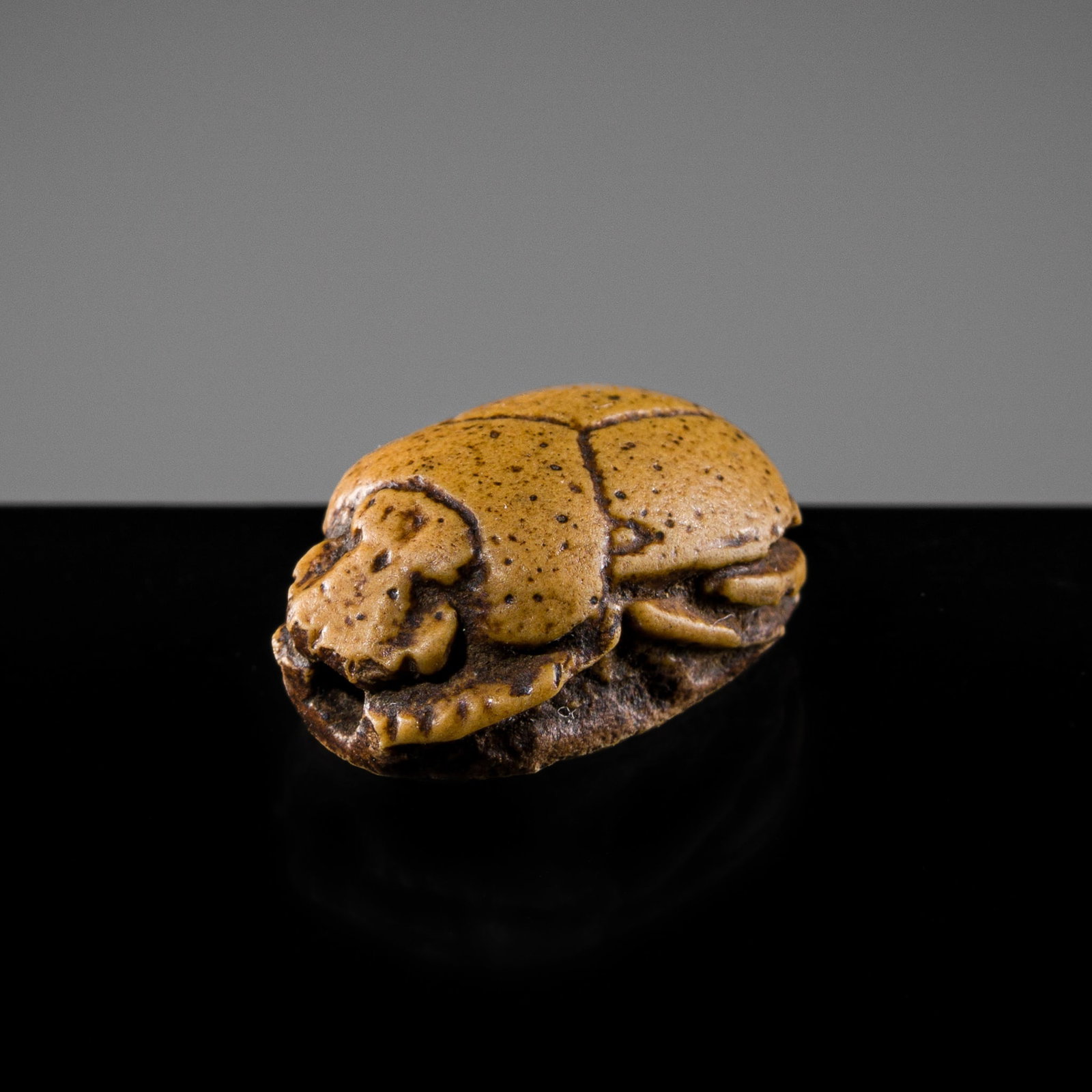 A RARE OCHRE-GLAZED STEATITE SCARAB SEAL, EARLY DYNASTY XVIII: A RARE OCHRE-GLAZED STEATITE SCARAB SEAL, EARLY DYNASTY XVIII This lot is from a single owner collection and is therefore offered without reserve Egypt, circa 1550-1480 BC. Oval in form, the domed car
