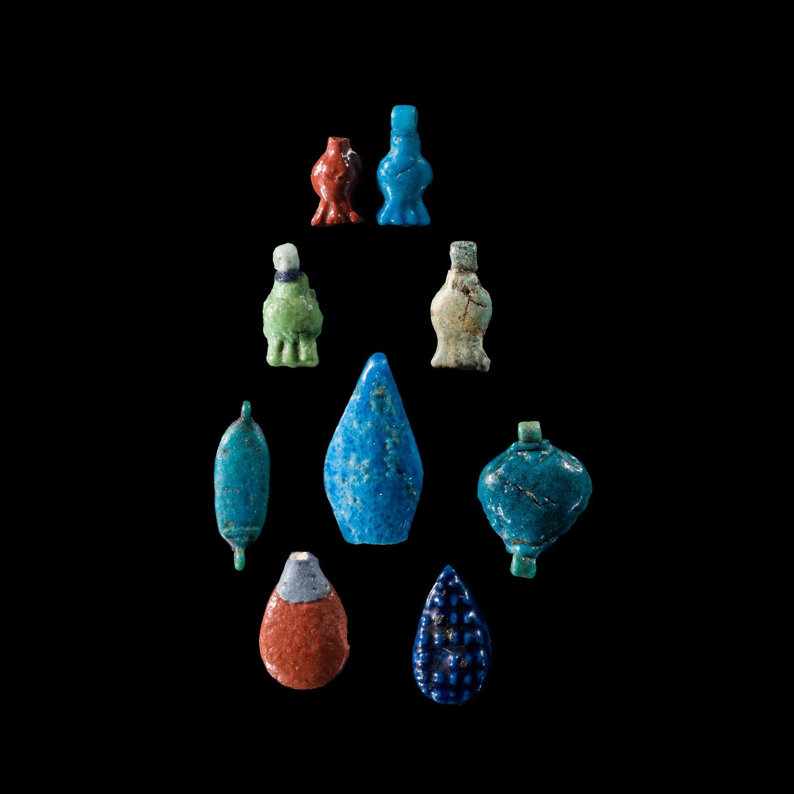 A GROUP OF NINE FAIENCE AMULETS, NEW KINGDOM, DYNASTY XVIII: A GROUP OF NINE FAIENCE AMULETS, NEW KINGDOM, DYNASTY XVIII This lot is from a single owner collection and is therefore offered without reserve Egypt, 1550-1292 BC. Comprising blue, green, red, and ye