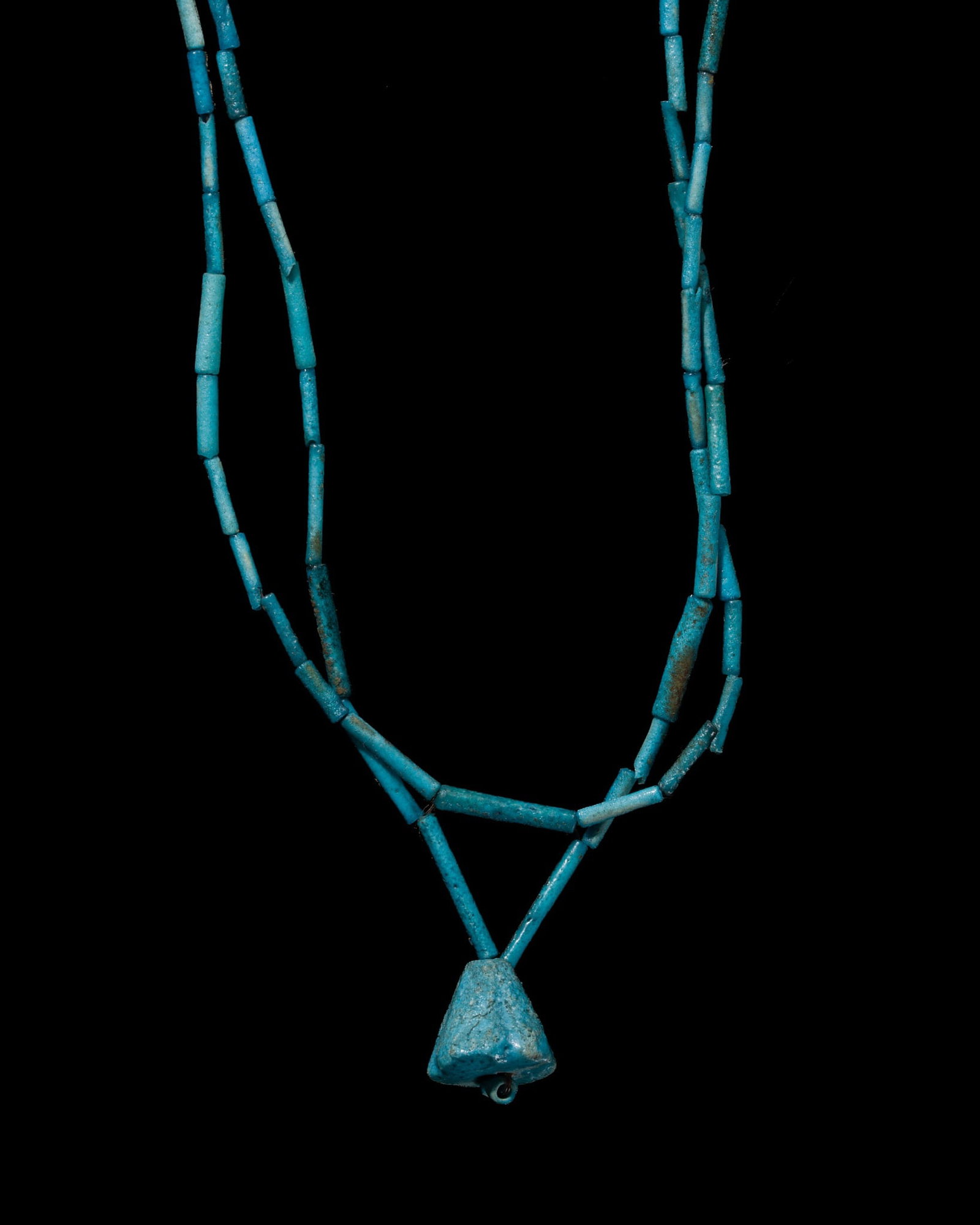 AN EGYPTIAN FAIENCE 'LOTUS' NECKLACE, LATE PERIOD: AN EGYPTIAN FAIENCE 'LOTUS' NECKLACE, LATE PERIOD This lot is from a single owner collection and is therefore offered without reserve Egypt, 664-332 BC. Composed of two strands totaling 125 long tubul