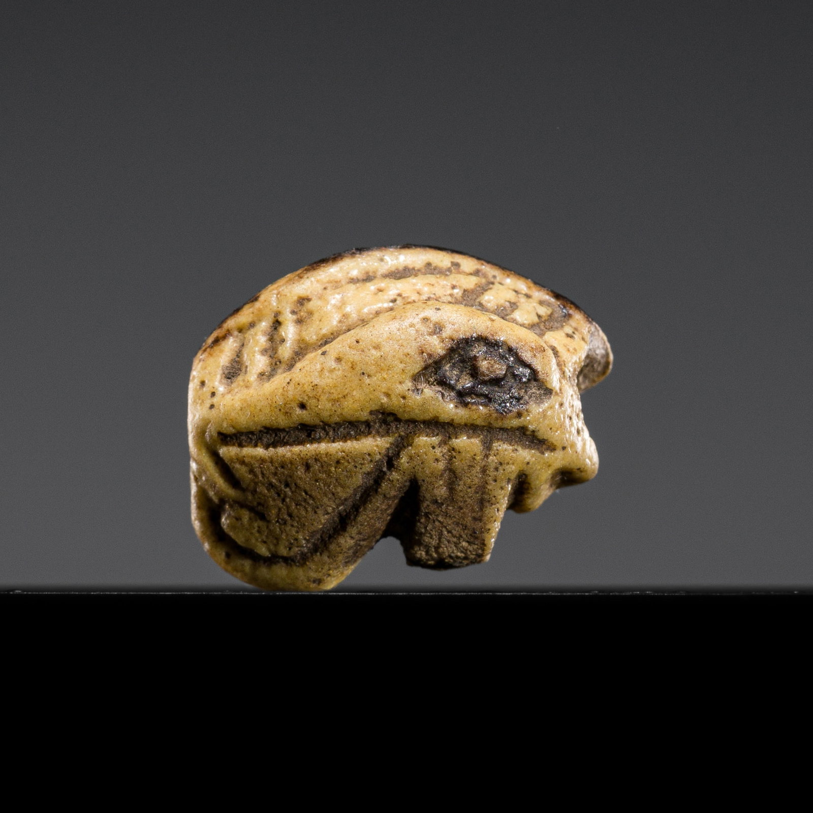 A RARE YELLOW FAIENCE 'WEDJAT-EYE' AMULET, THIRD INTERMEDIATE PERIOD (1 of 10)
