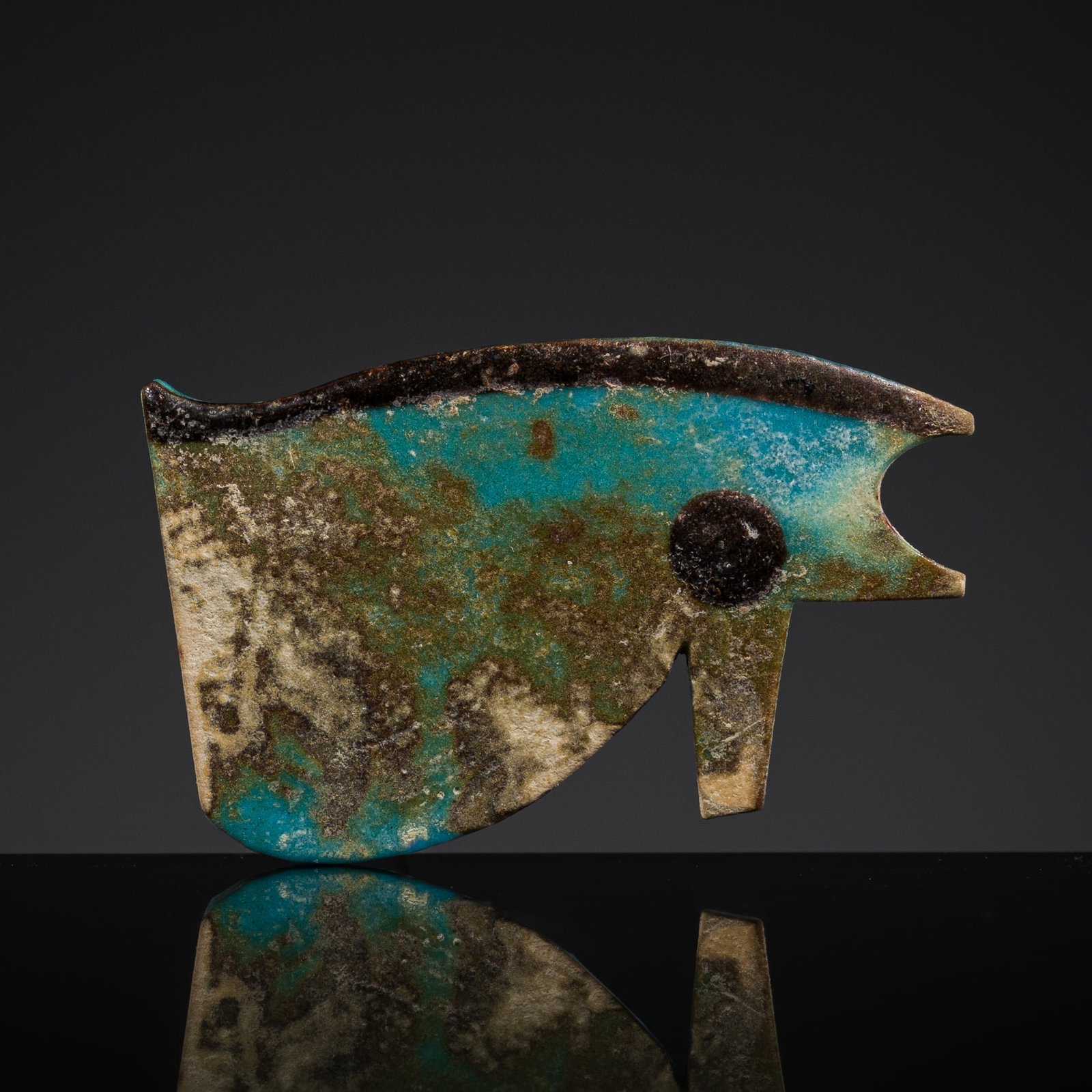 A BLUE FAIENCE WEDJAT-EYE AMULET, THIRD INTERMEDIATE PERIOD-LATE PERIOD (1 of 13)
