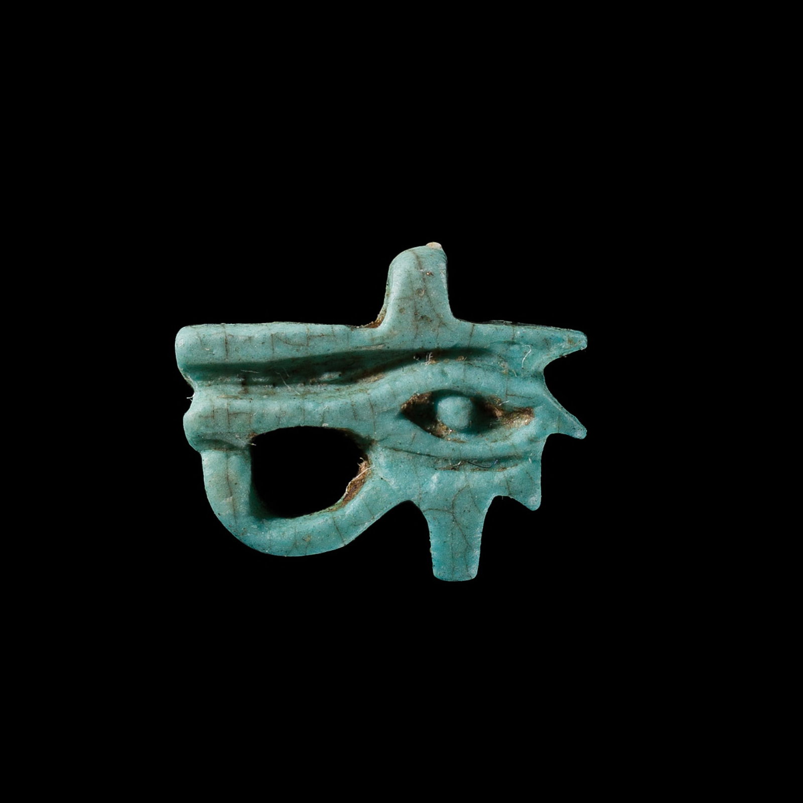 A TURQUOISE FAIENCE WEDJAT EYE AMULET, LATE PERIOD: A TURQUOISE FAIENCE WEDJAT EYE AMULET, LATE PERIOD This lot is from a single owner collection and is therefore offered without reserve Egypt, 664-332 BC. Finely modeled in the form of the left Eye of 