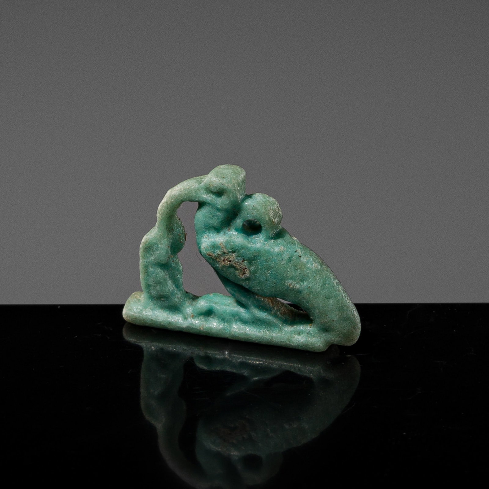 A TURQUOISE FAIENCE AMULET OF AN IBIS OF THOTH, LATE PERIOD-PTOLEMAIC PERIOD: A TURQUOISE FAIENCE AMULET OF AN IBIS OF THOTH, LATE PERIOD-PTOLEMAIC PERIOD This lot is from a single owner collection and is therefore offered without reserve Egypt, 664-30 BC. Depicted in a squatti