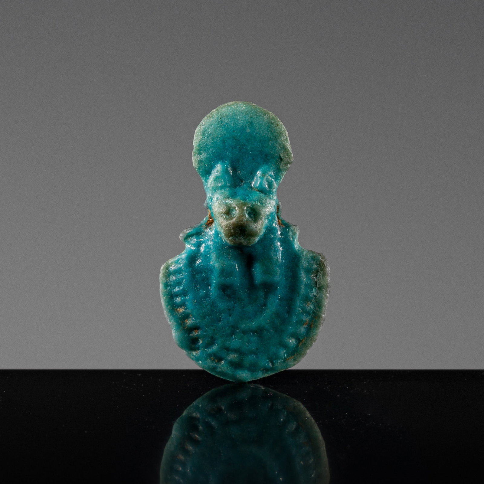A TURQUOISE FAIENCE AEGIS AMULET OF SEKHMET, LATE PERIOD: A TURQUOISE FAIENCE AEGIS AMULET OF SEKHMET, LATE PERIOD This lot is from a single owner collection and is therefore offered without reserve The Jorgen Ruben Gallery Ledger, entry from 2005: “No