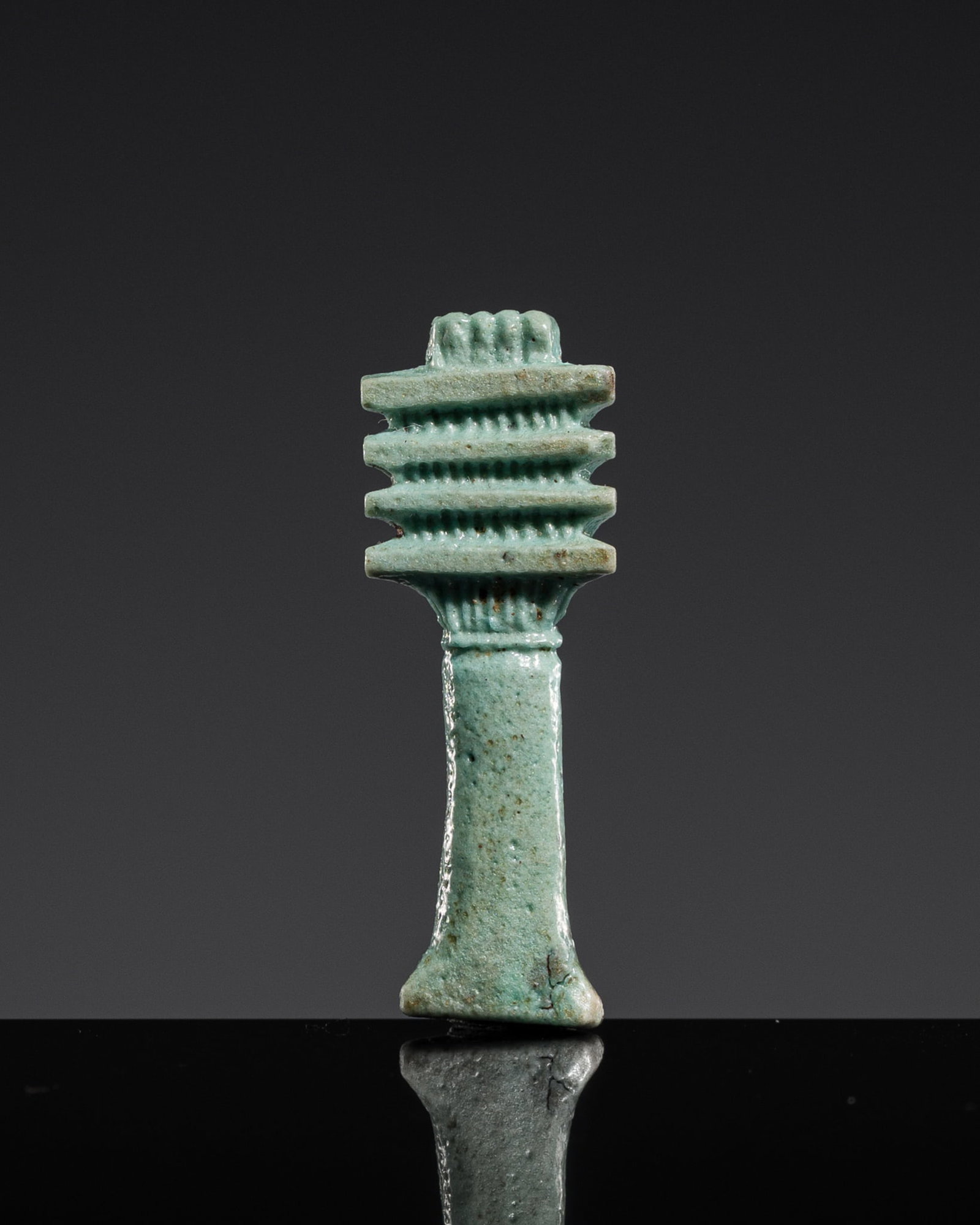 A TURQUOISE FAIENCE DJED-PILLAR AMULET, LATE PERIOD: A TURQUOISE FAIENCE DJED-PILLAR AMULET, LATE PERIOD This lot is from a single owner collection and is therefore offered without reserve Egypt, 664-332 BC. Well modeled with a gently waisted vertical s