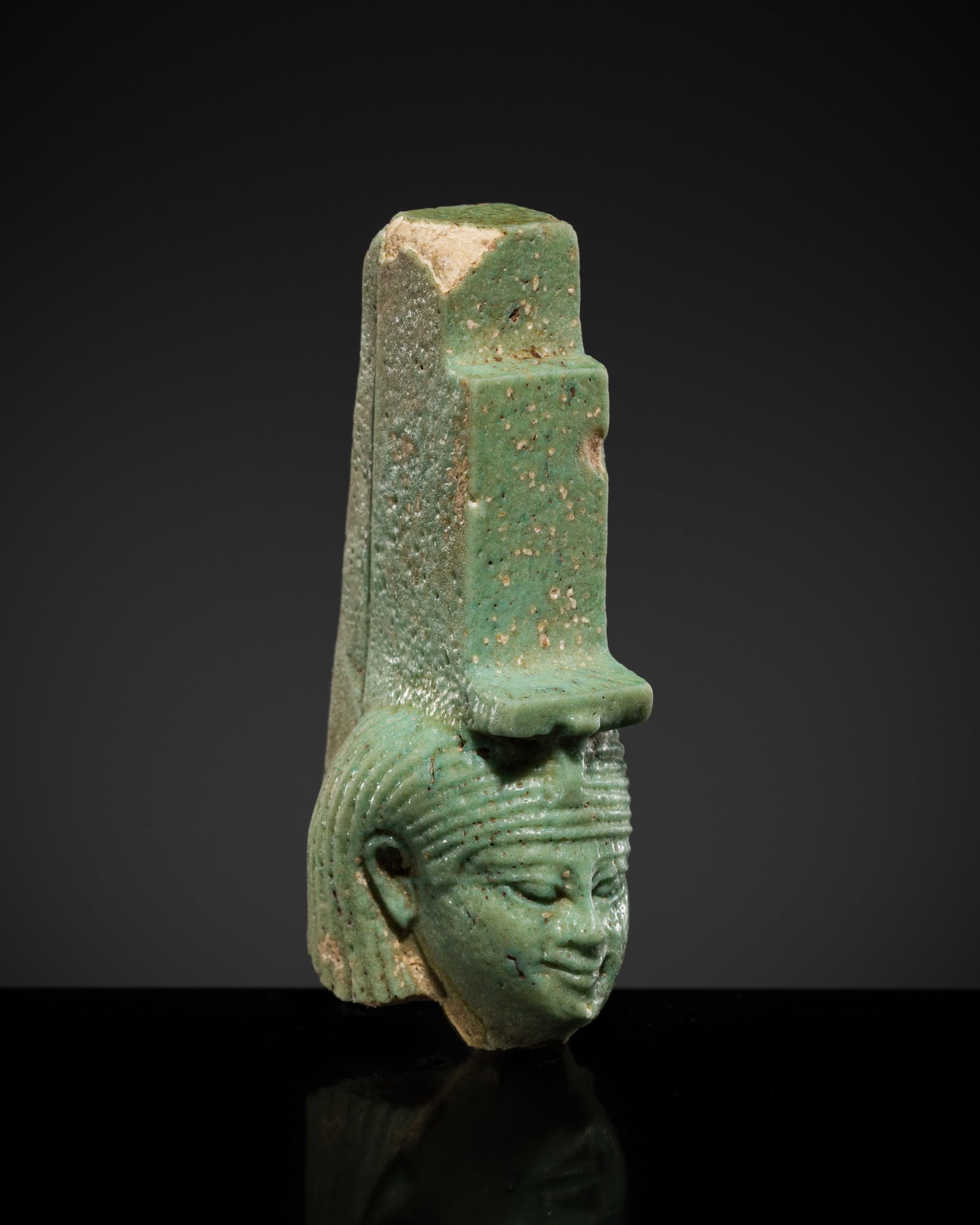 A TURQUOISE FAIENCE HEAD OF ISIS, LATE PERIOD-PTOLEMAIC PERIOD: A TURQUOISE FAIENCE HEAD OF ISIS, LATE PERIOD-PTOLEMAIC PERIOD This lot is from a single owner collection and is therefore offered without reserve The Jorgen Ruben Gallery Ledger, entry from 2005: 