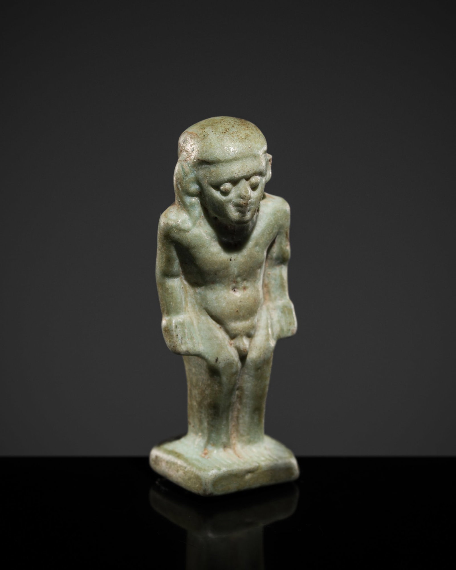 A PALE TURQUOISE FAIENCE AMULET OF PATAIKOS, LATE PERIOD TO PTOLEMAIC ERA (1 of 13)