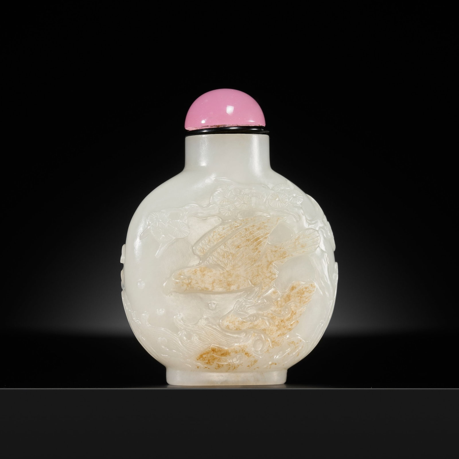 A WHITE JADE AND RUSSET 'EAGLE AND PINE' SNUFF BOTTLE, 1750-1850: A WHITE JADE AND RUSSET 'EAGLE AND PINE' SNUFF BOTTLE, 1750-1850 China. Well hollowed, of flattened globular form rising from an oval foot to a tubular neck with flat lip, the surface carved in relief
